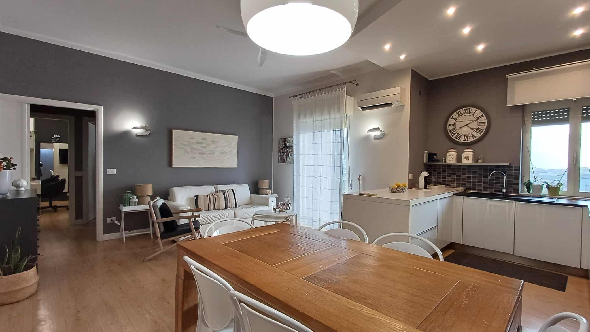 Accogliente soggiorno e cucina moderna open space in appartamento NextCasa, arredato con gusto e funzionalità, ideale per vivere negli spazi più confortevoli e luminosi.