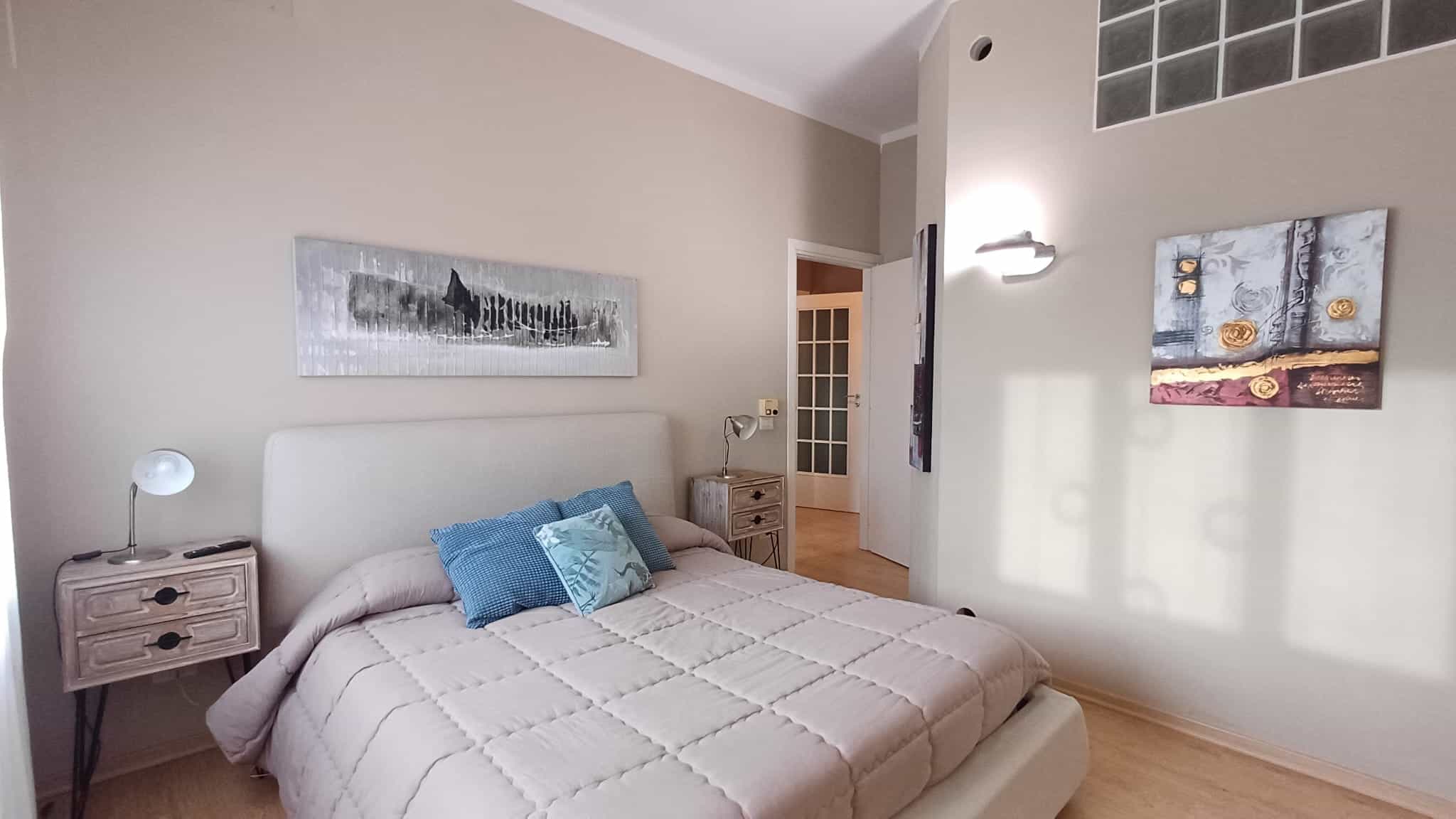 Appartamento arredato con design moderno, camera da letto con letto matrimoniale e decorazioni artistiche, atmosfera accogliente, ideale per acquisto o affitto immobiliare.