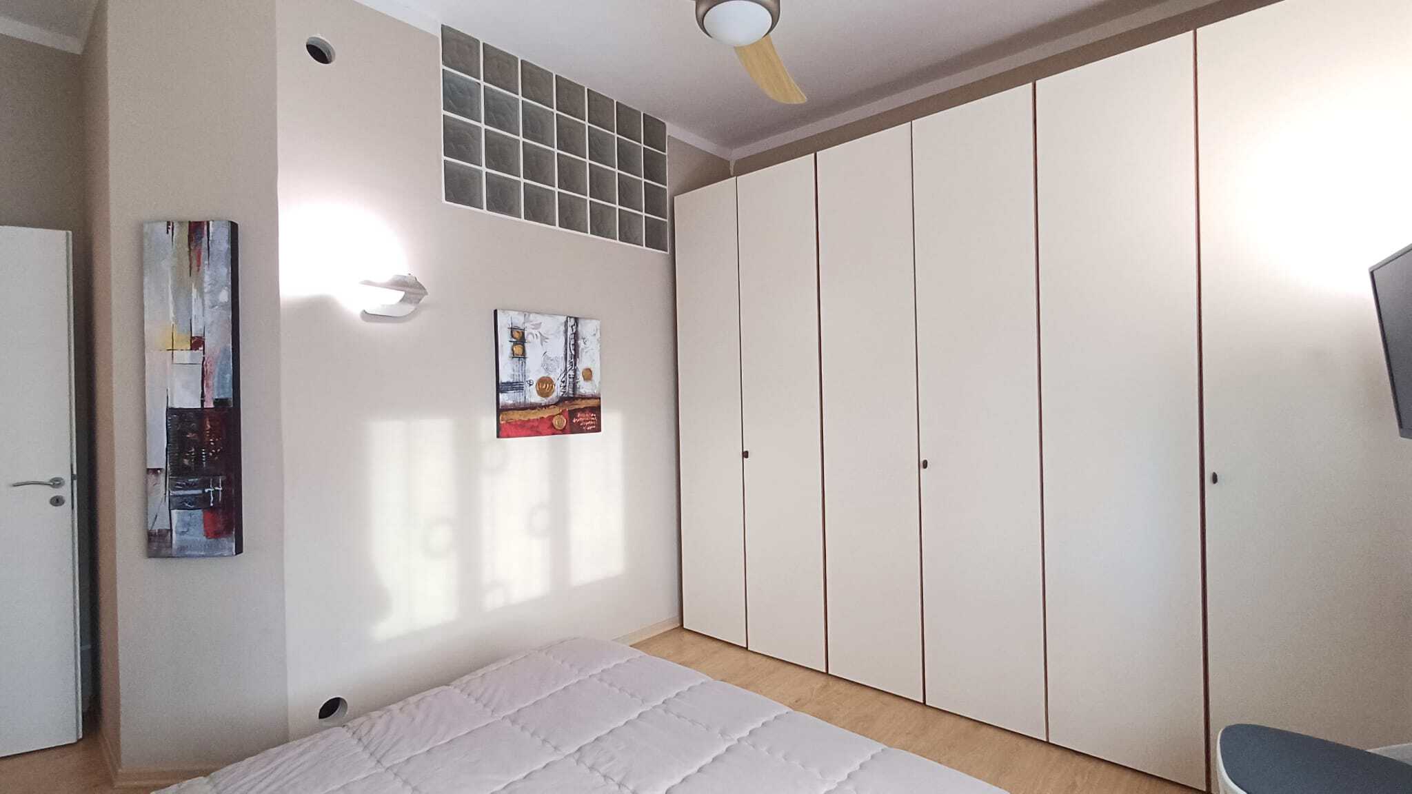 Armadio a muro bianco in camera da letto, arredamento elegante e funzionale, ideale per soluzioni abitative moderne e compatte.
