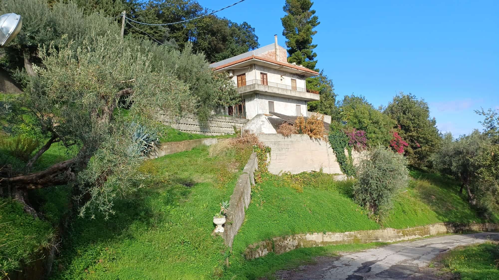 1. Casa di montagna immersa nel verde con terrazza e giardino su collina, vista panoramica e natura rigogliosa, ideale per seconde case o residenza tranquilla.
