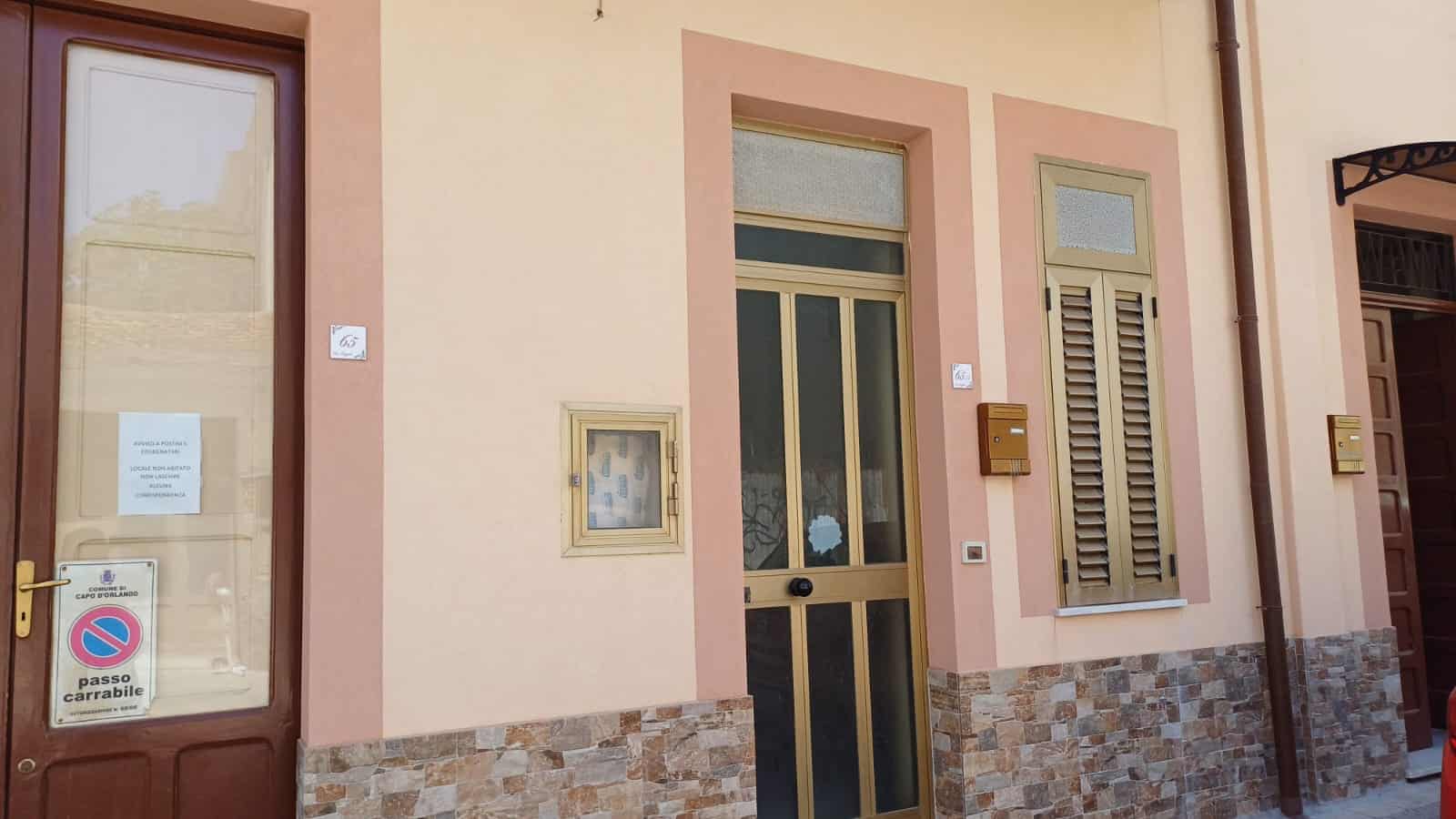 Finestra e porta di un appartamento a Capo d'Orlando, in stile mediterraneo, con rifiniture in pietra e dettagli in beige, ideale per proprietà residenziali e immobili da comprare o affittare.