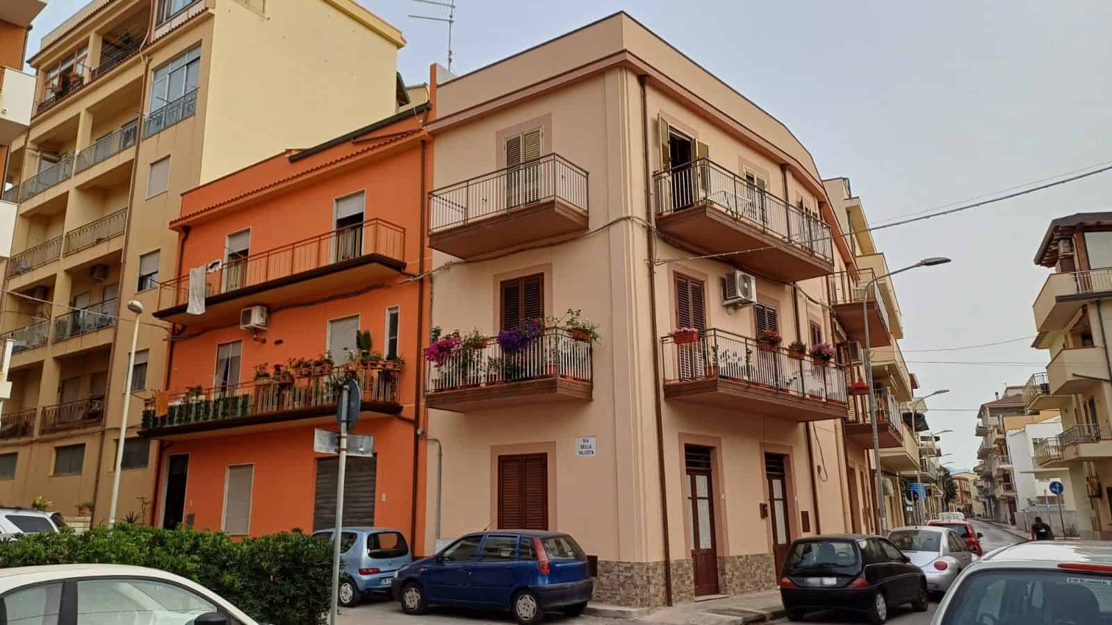 1.Edificio residenziale a Palermo con balconi fioriti e aria mediterranea, zona tranquilla, ideale per vivere o investire, vicino a servizi e trasporti, con carattere e stile autentico.