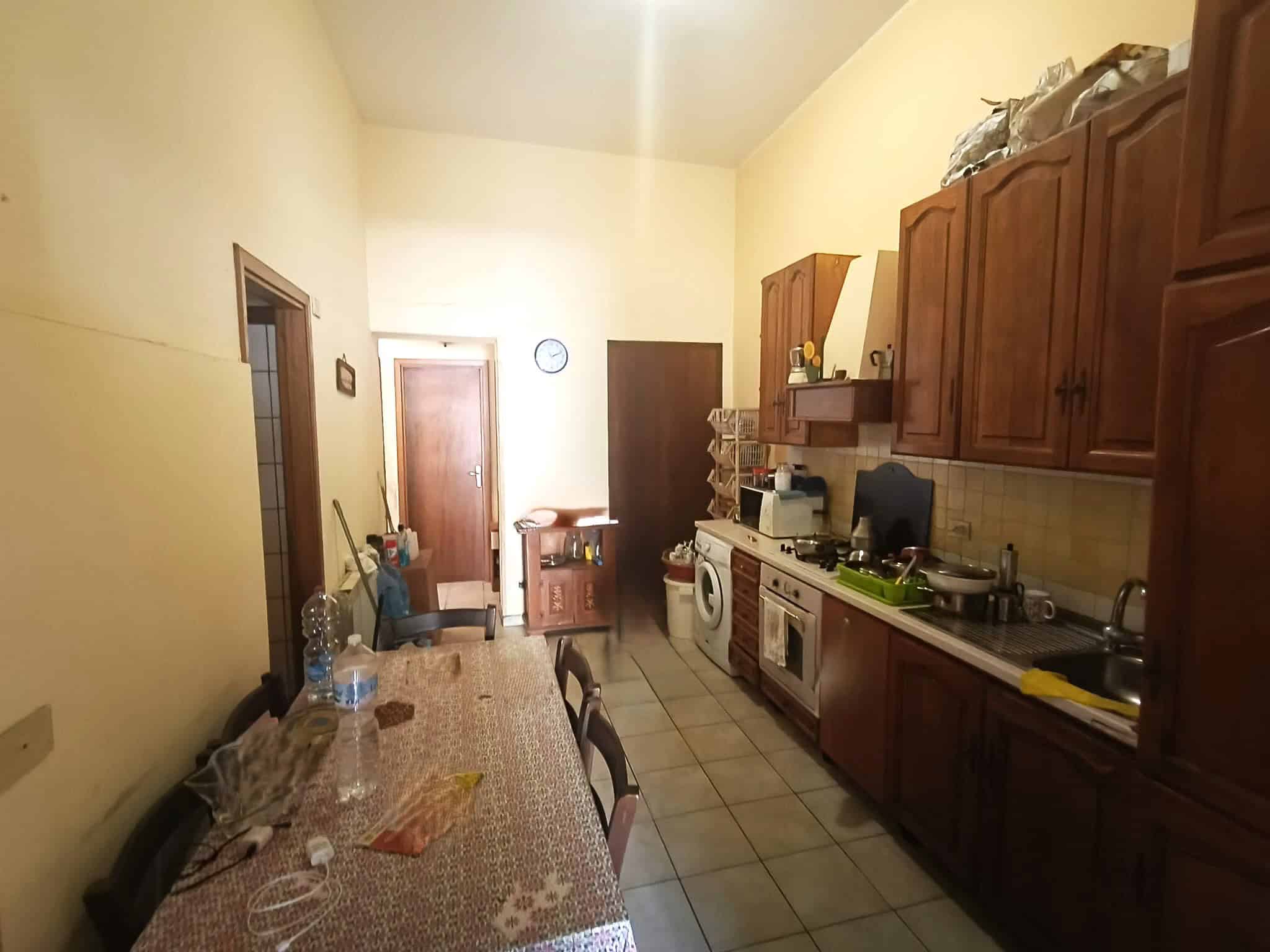 1. Cucina abitabile con mobili in legno, lavello, elettrodomestici, tavolo e sedie, ambiente accogliente e funzionale.
