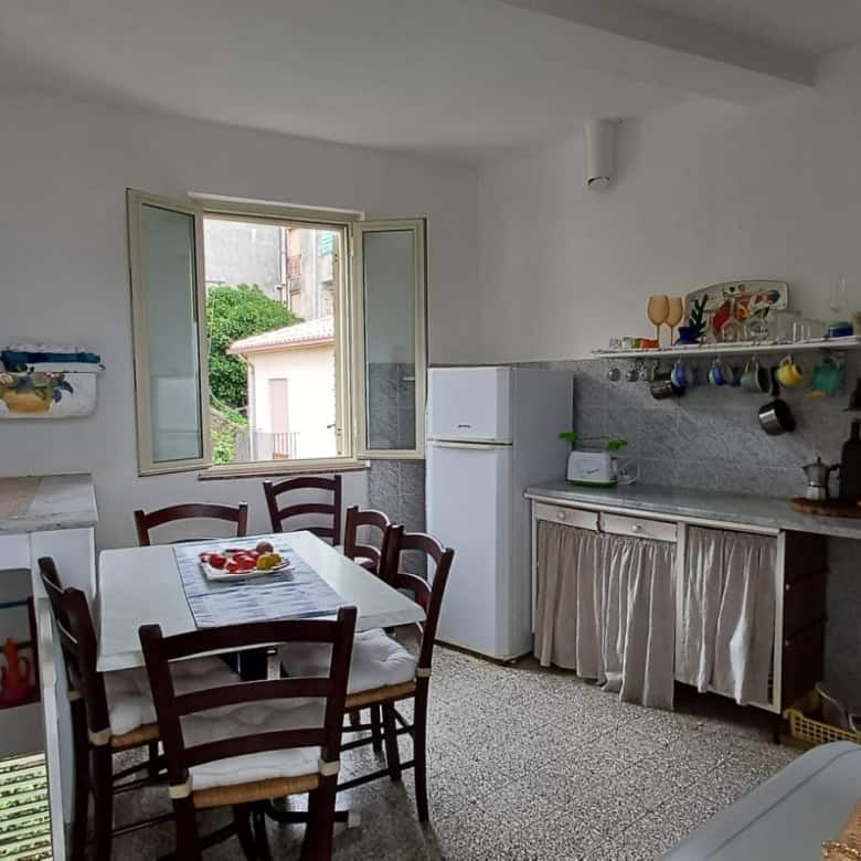 Ampia cucina abitabile con finestra, frigorifero, forno e stoviglie, ideale per soggiorni confortevoli e pratici in casa NextCasa.