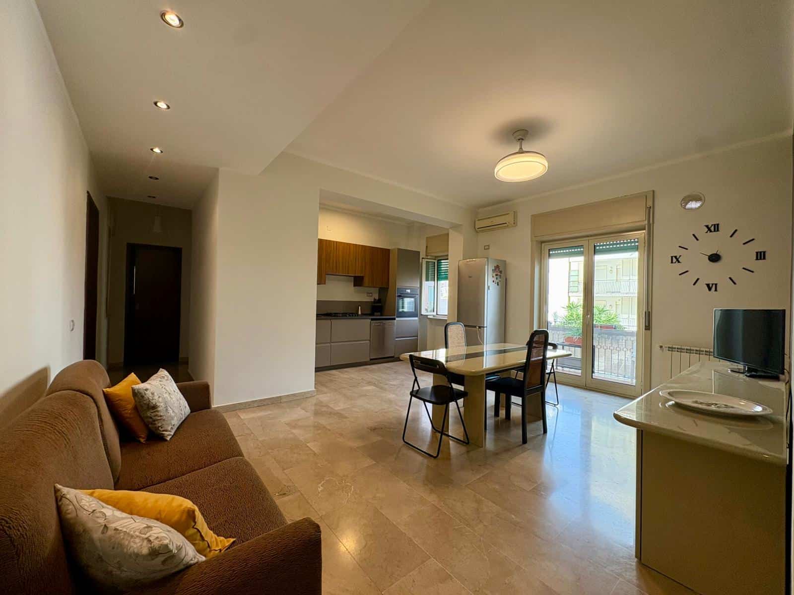 Ampio soggiorno e cucina a vista in appartamento NextCasa, con zona pranzo, balcone panoramico e arredamento moderno. Ideale per vivere in comfort e stile nel cuore della città.