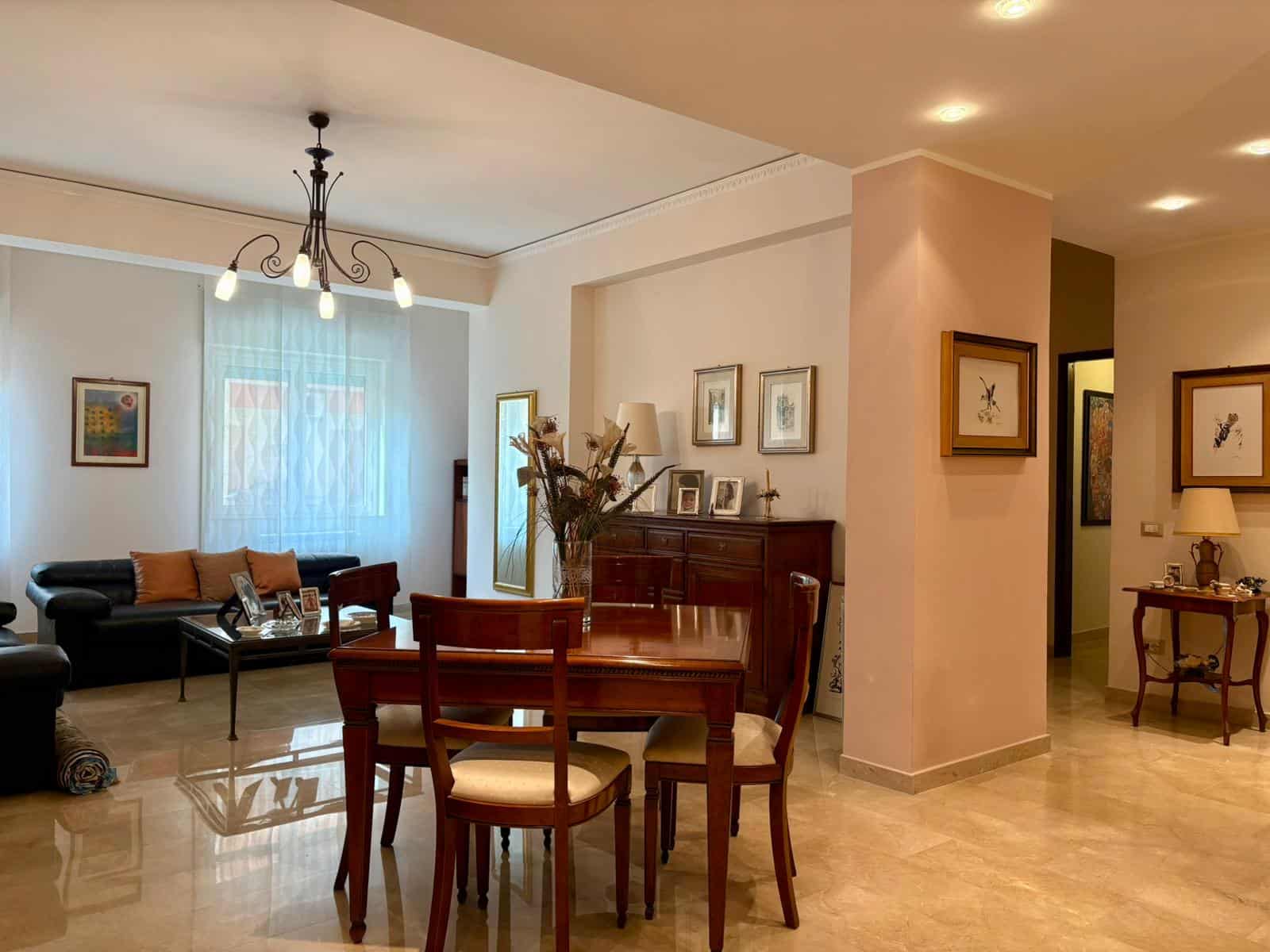 Accogliente soggiorno arredato con divani in pelle, tavolo in legno e splendide decorazioni, ambientazione luminosa con luce naturale, ideale per case di design e comfort.