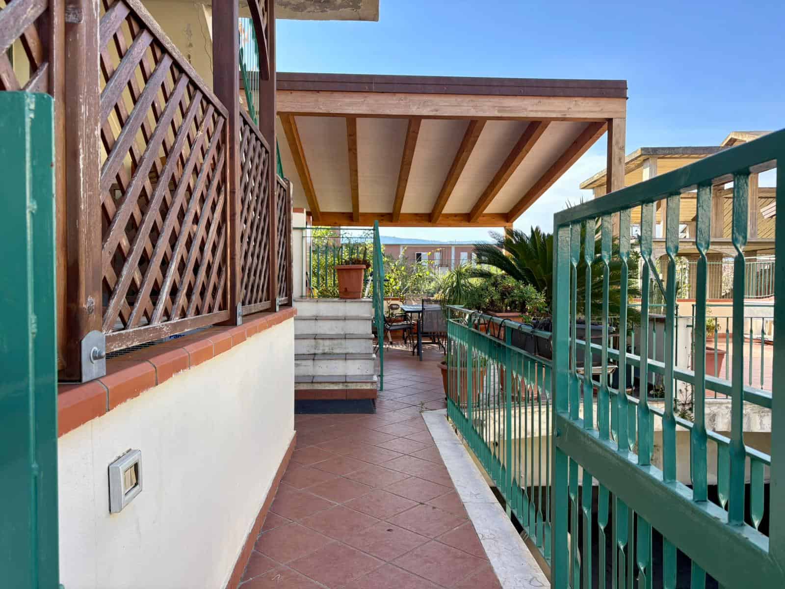 Balcone di appartamento con piante e vista panoramica, spazio esterno ben curato, ideale per relax e convivialità, arredi esterni moderni, atmosfera luminosa e accogliente, zona living all'aperto.