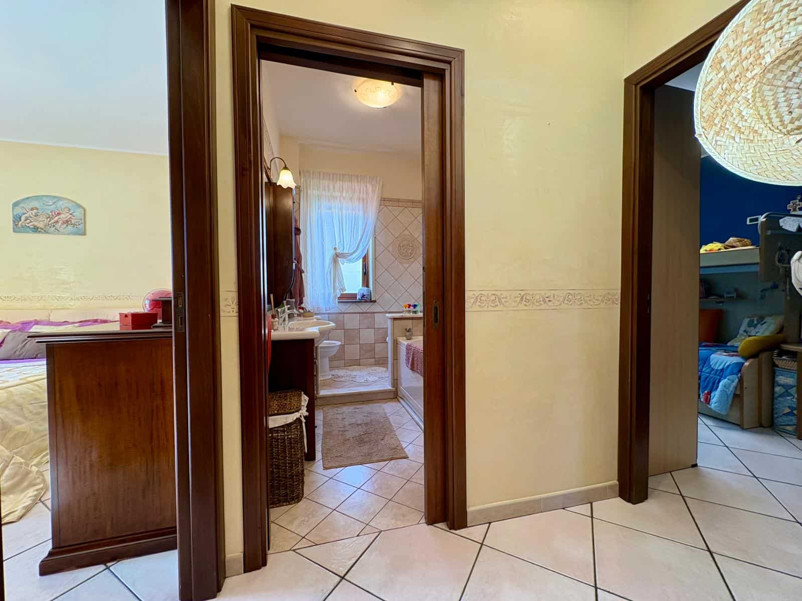 1. Bagno con tenda doccia, lavabo, finestra e arredamento in stile classico, vista interna di una casa vicina al mare.
