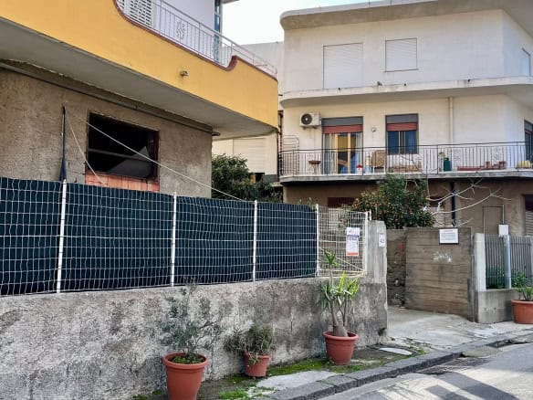 Stanziamento di una casa in vendita con lavori di ristrutturazione in corso, con recinzione e spazio esterno, zona residenziale vicino a servizi, ideale per investimento immobiliare.