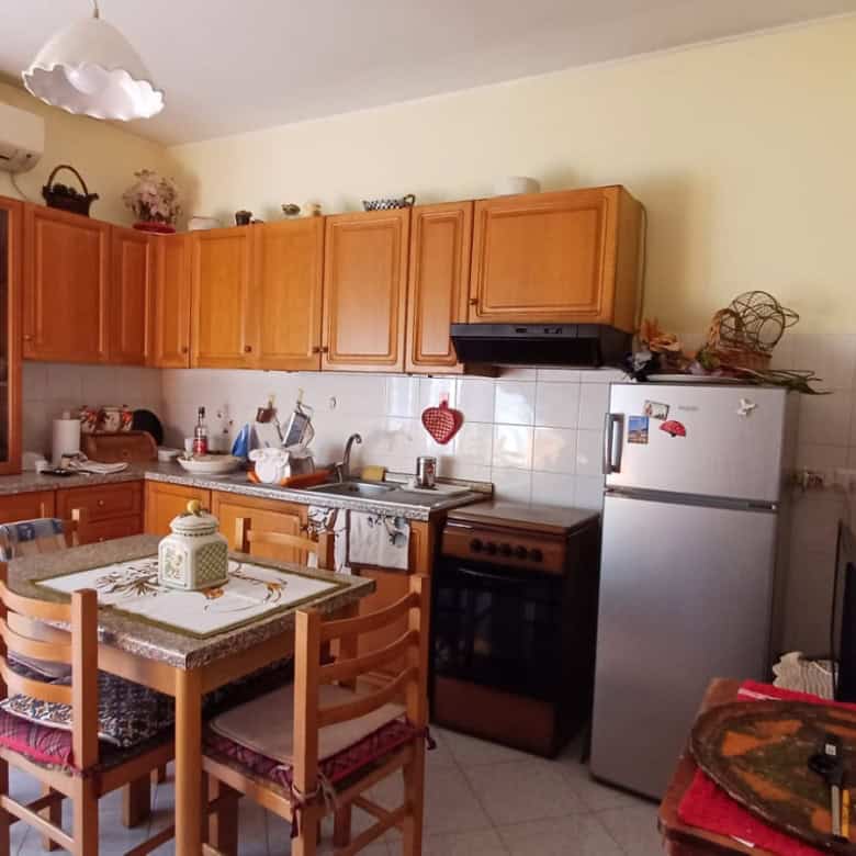 1. Cucina abitabile con mobili in legno, frigorifero e forno, ambiente accogliente con decorazioni e utensili da cucina.