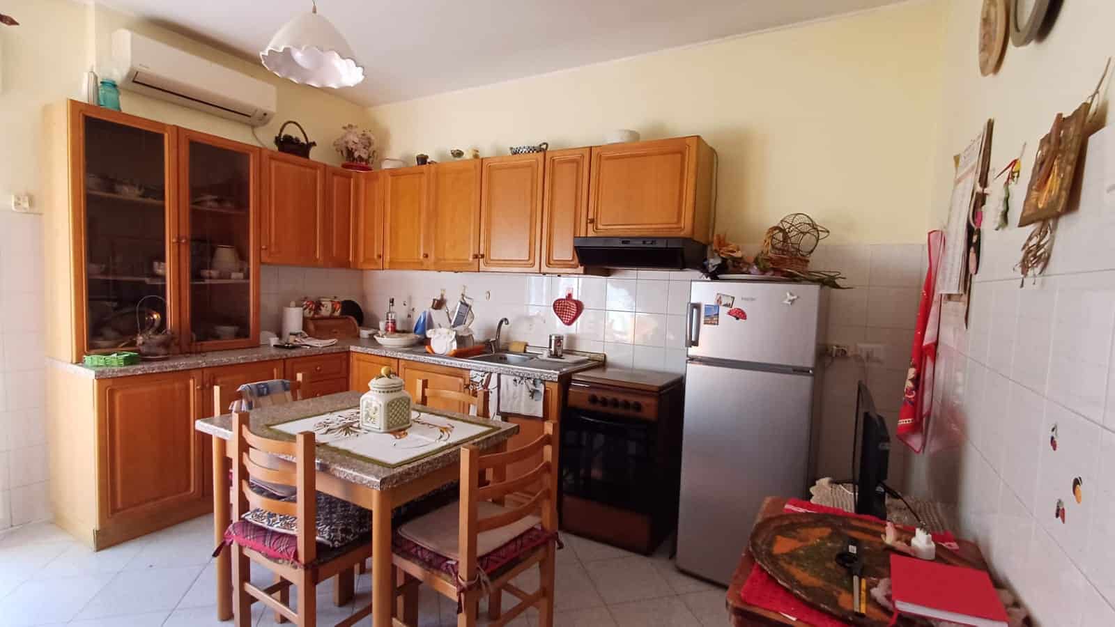 1. Cucina abitabile con mobili in legno, frigorifero e forno, ambiente accogliente con decorazioni e utensili da cucina.