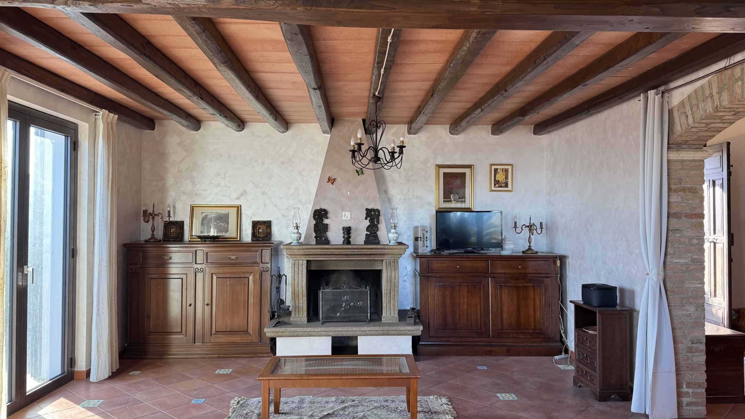 1. Immagine di un soggiorno rustico con soffitto in legno, camino in pietra e mobili in legno massello, atmosfera calda e accogliente.