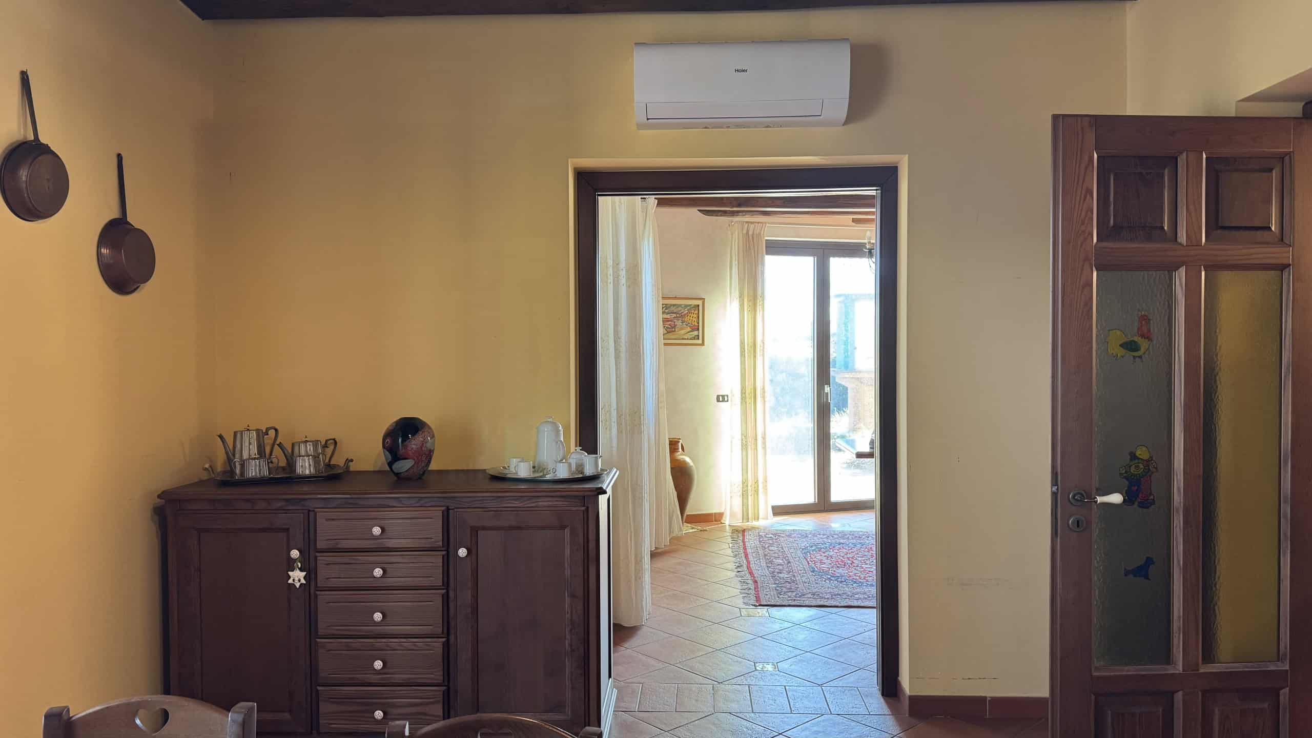Armadietto in legno nella stanza con pareti gialle, decorazioni e accessori in stile classico, vista su un'area luminosa e accogliente, foto di un interno di casa di qualità, perfetta per immobili residenziali.