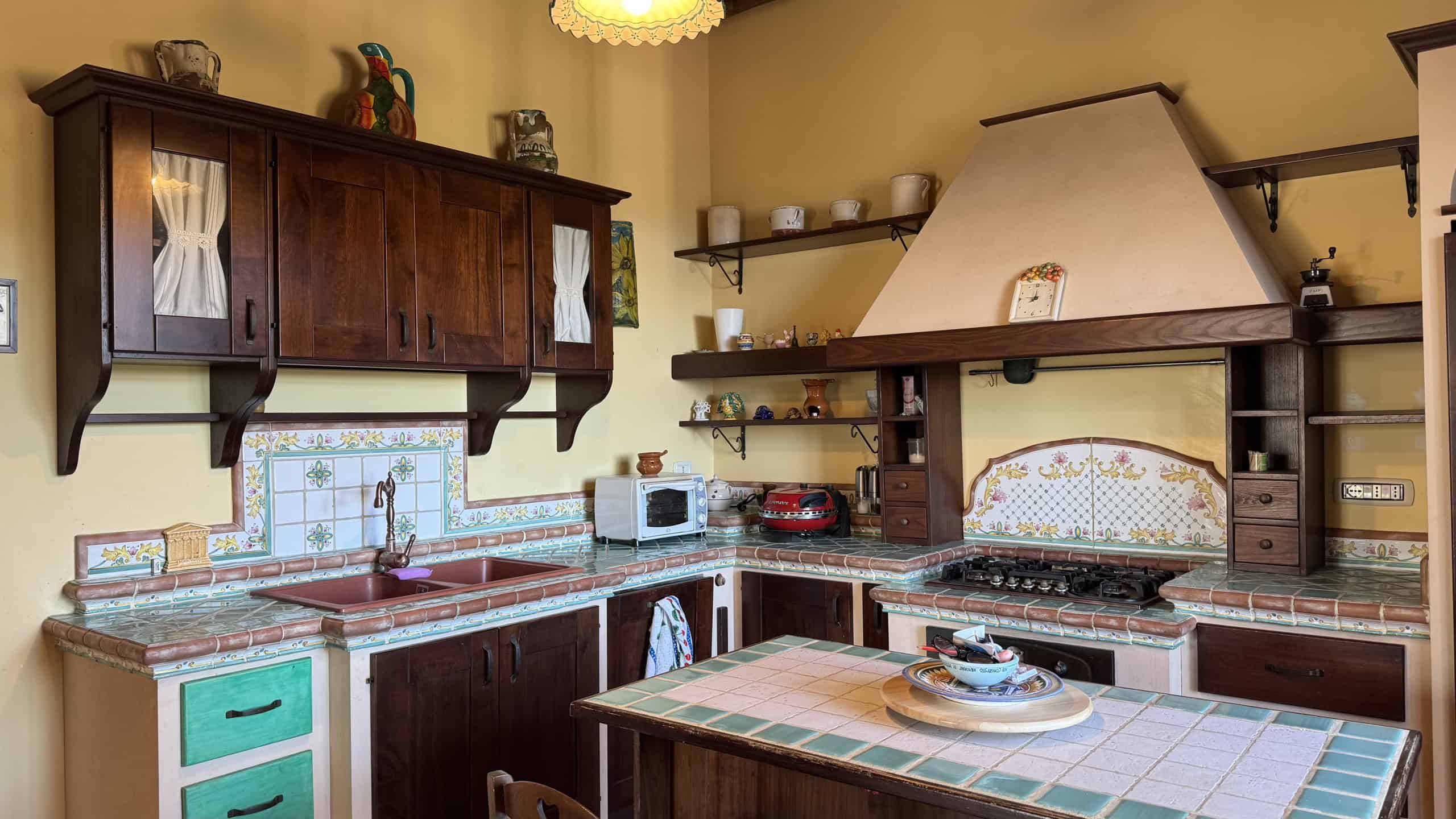 1. Cucina rustica con ante in legno scuro, piastrelle colorate e dettagli tradizionali, perfetta per case di campagna e ambienti accoglienti.