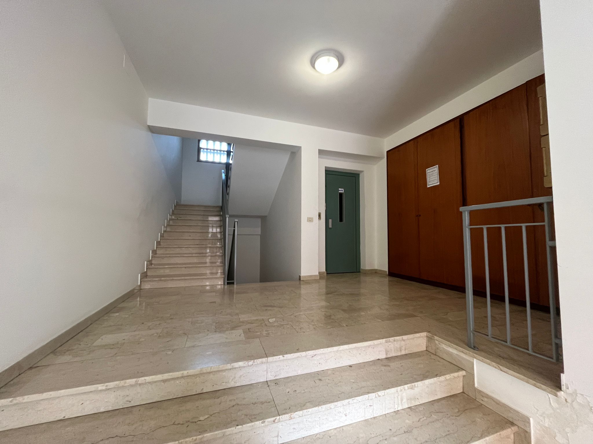 Escalator centrale in edificio residenziale con pavimentazione in marmo e pareti bianche. Presenza di ascensore e spazi ampi, luminosi e ben curati. Ideale per appartamenti e uffici di qualità.
