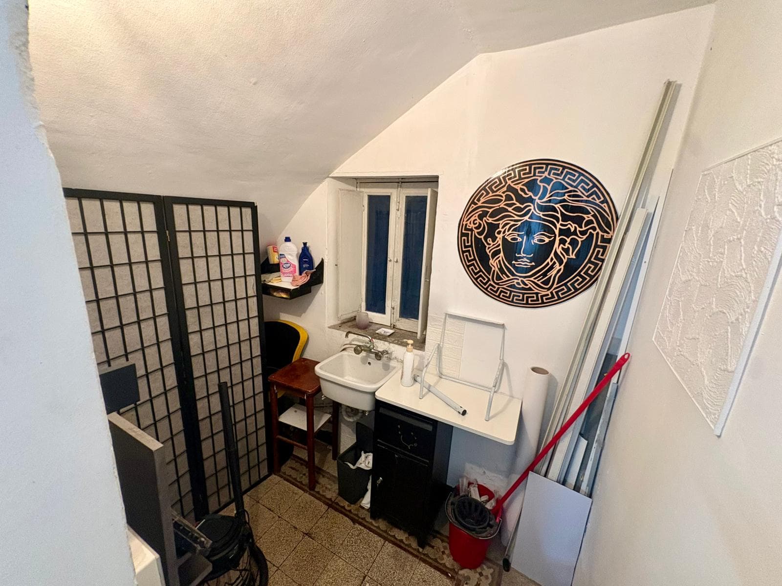 Lavabo e accessori bagno in un ambiente compatto con decorazioni moderne e arredi funzionali, ideale per spazi ristretti.