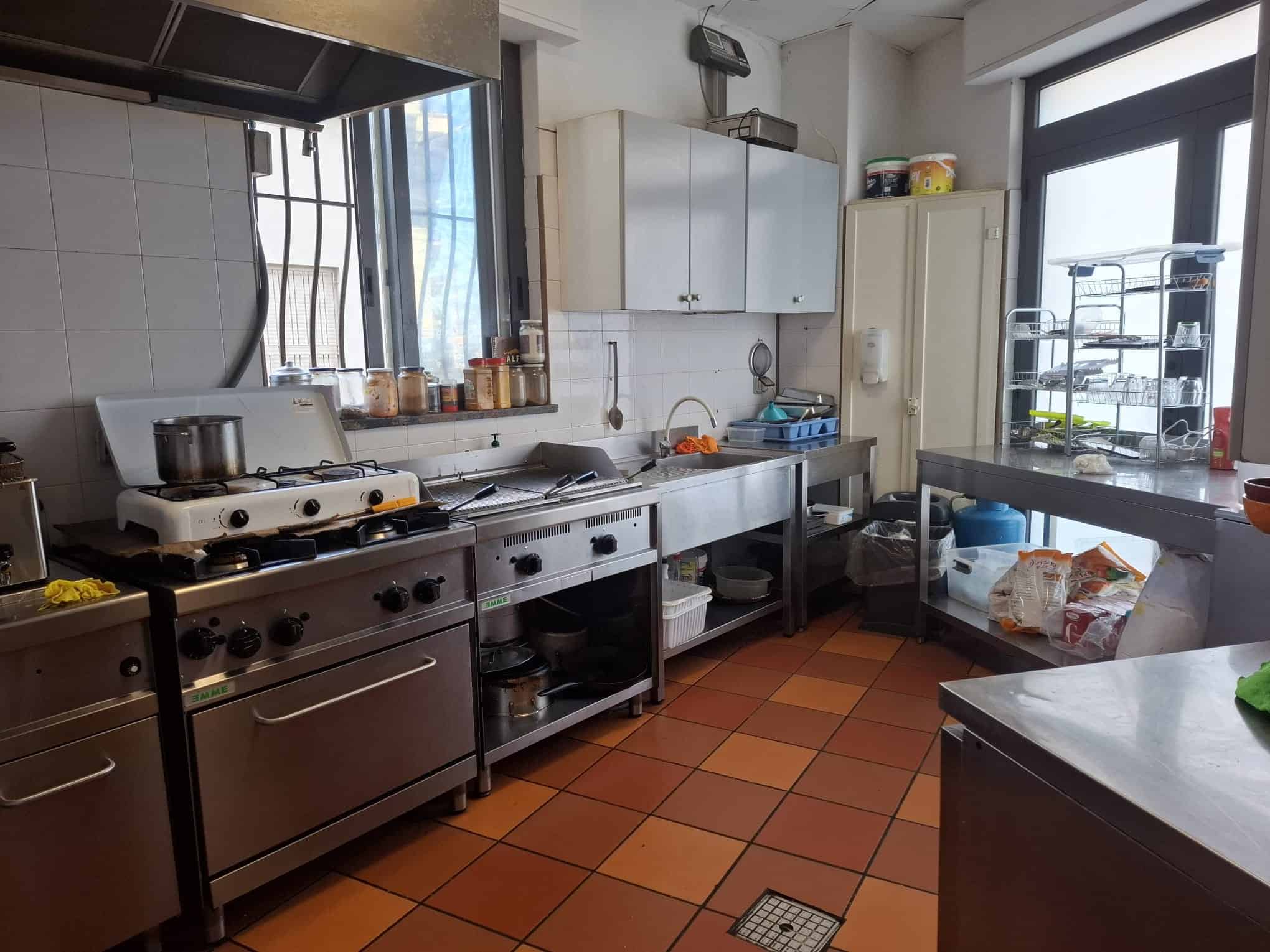 Cibo e attrezzature da cucina professionale in un ambiente di ristorante o cucina industriale.