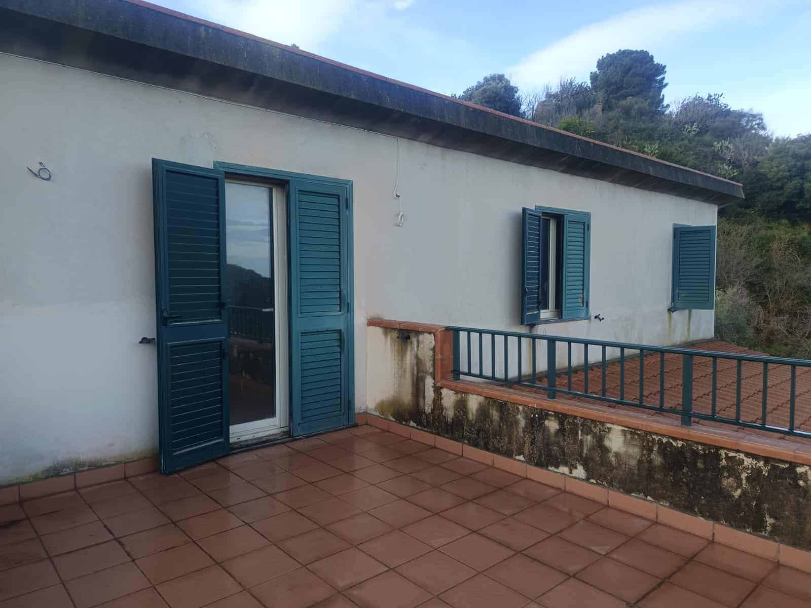 Balcone con persiane in legno blu e vista su natura, ideale per case vacanza e immobili in vendita in Italia.