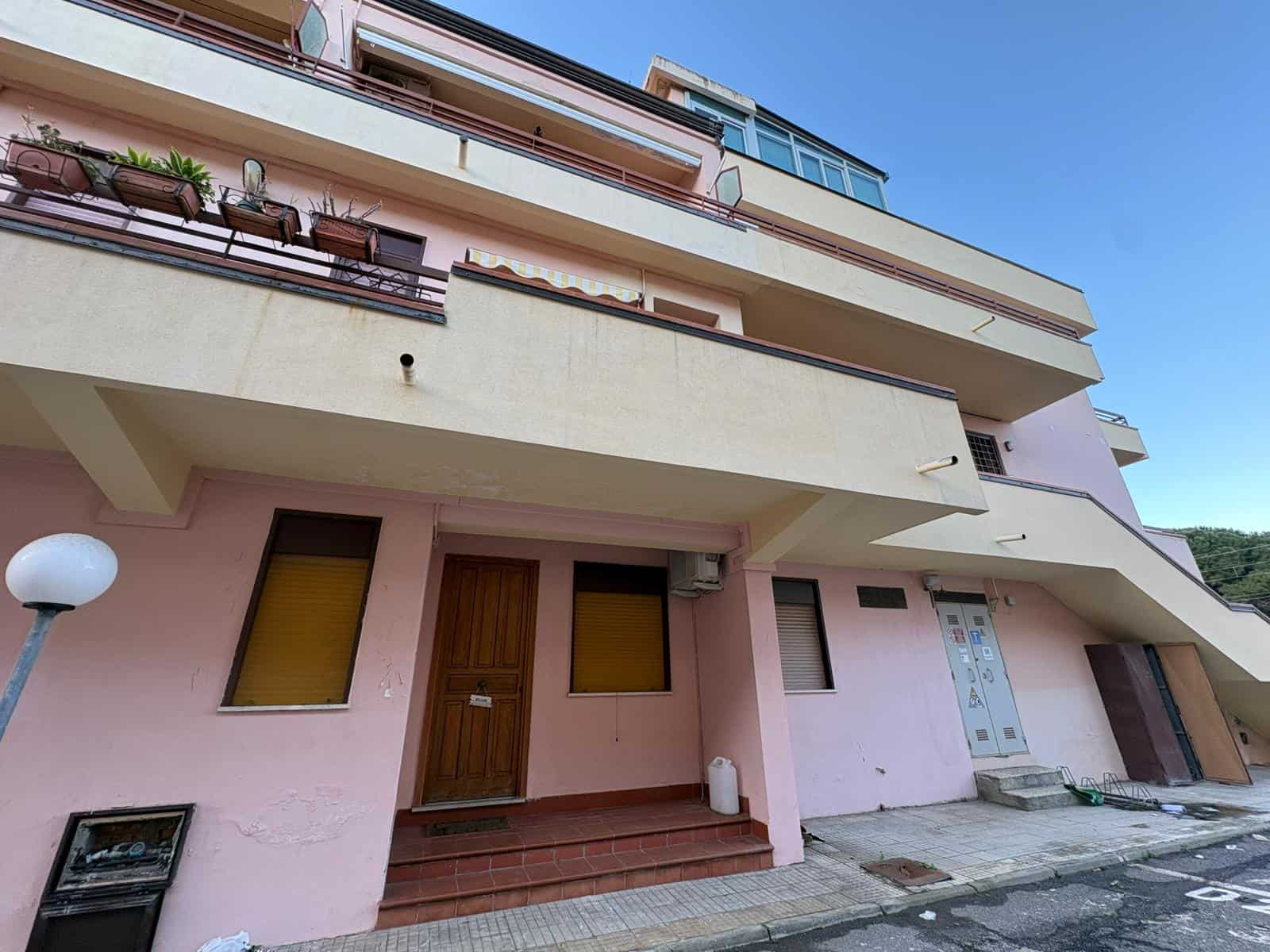Appartamento moderno con balconi e ingresso in zona residenziale, vista esterna di edificio multifamiliare a più piani.