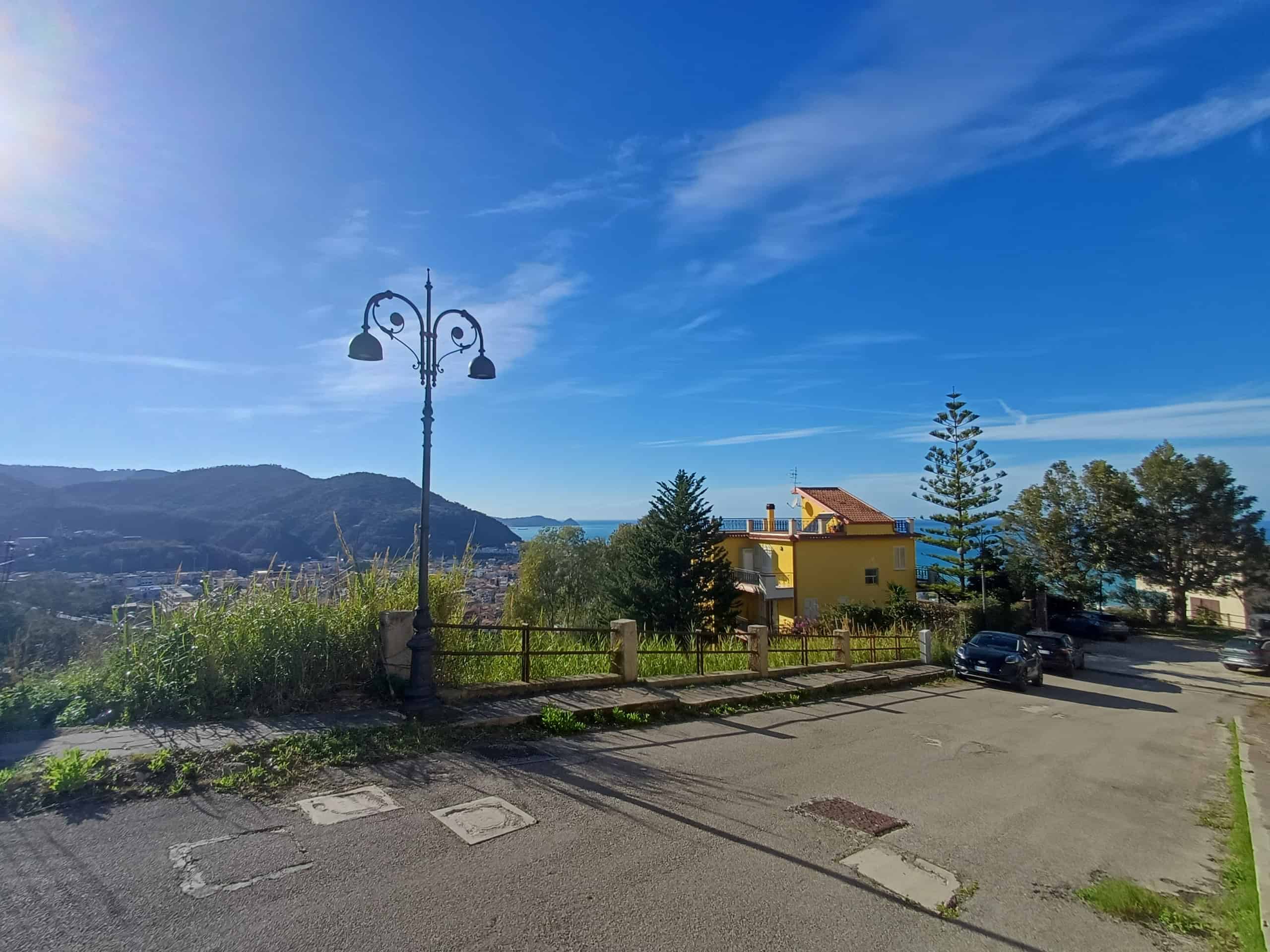 Palo della luce vintage con vista panoramica sul mare e sulle colline circostanti, in un quartiere residenziale tranquillo.