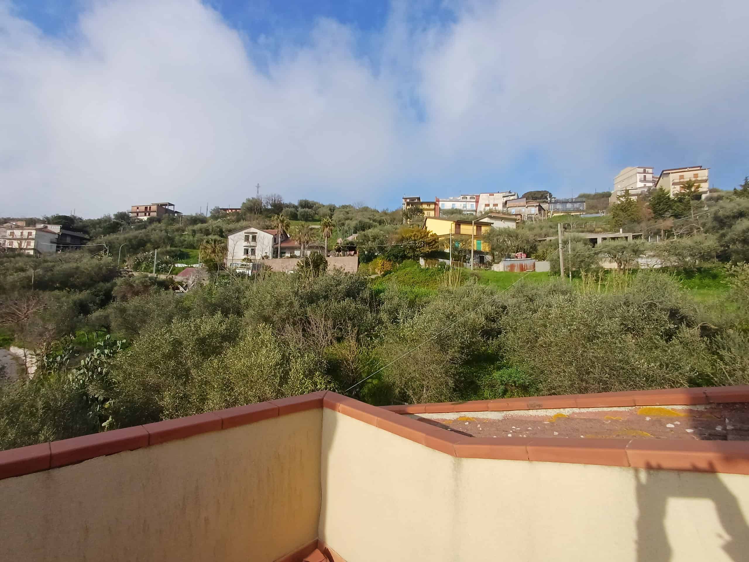 Panorama di Ficarra con case e colline verdi, cielo nuvoloso, vista dalla terrazza di una casa indipendente in vendita a Matini, Ficarra, Me.