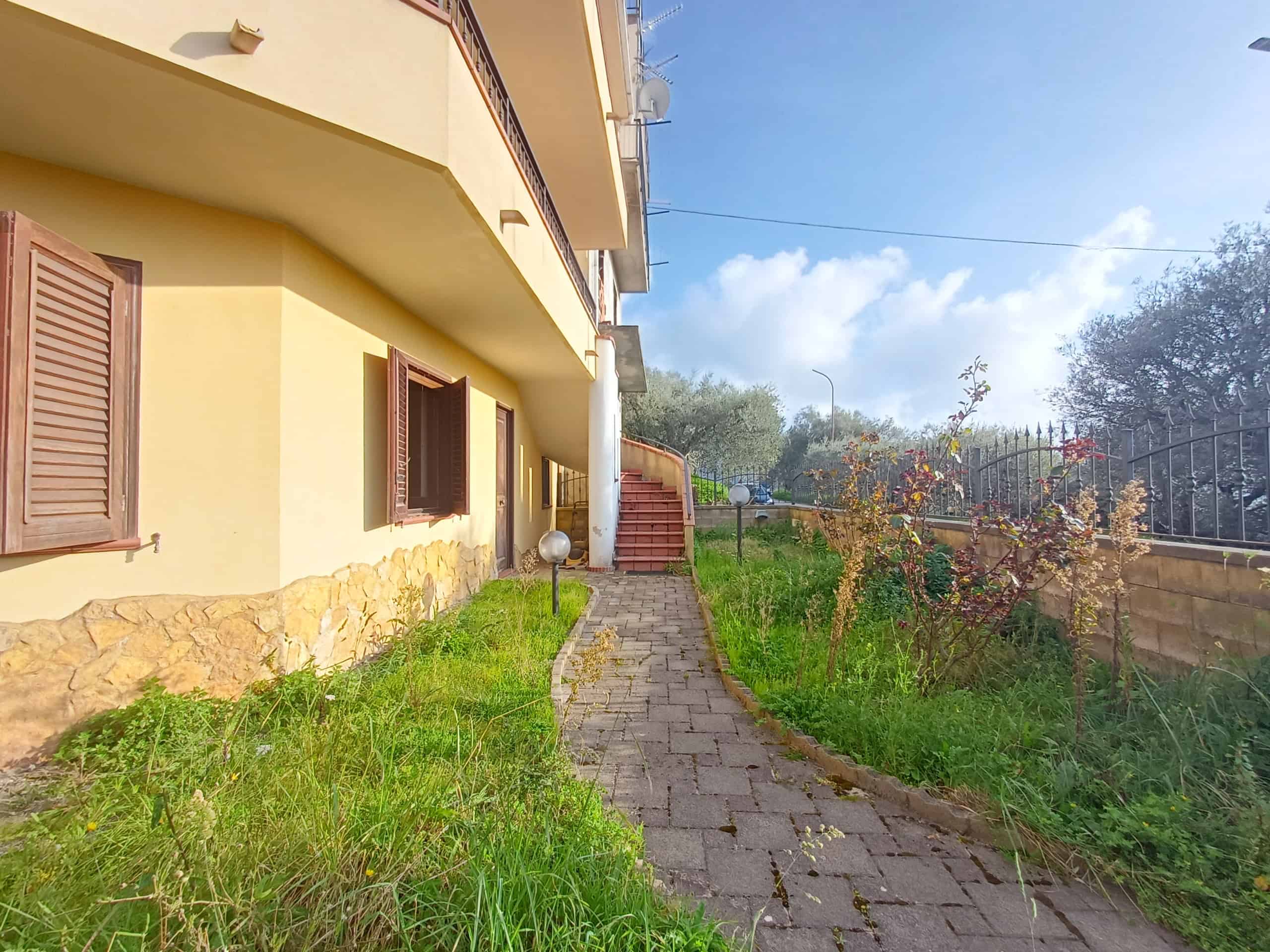 Esterno di una casa indipendente a Ficarra con giardino e percorso pedonale, in zona tranquilla e ben curata.