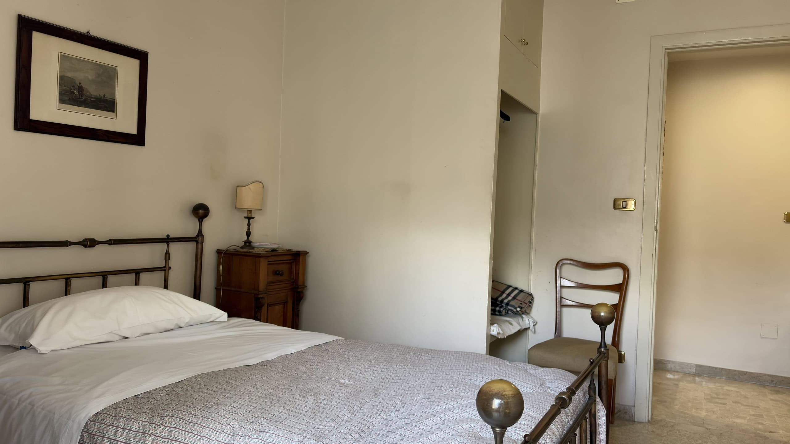 Ampio soggiorno con letto matrimoniale, arredamento classico e atmosfera accogliente, ideale per affitti turistici o residenziali in Italia.