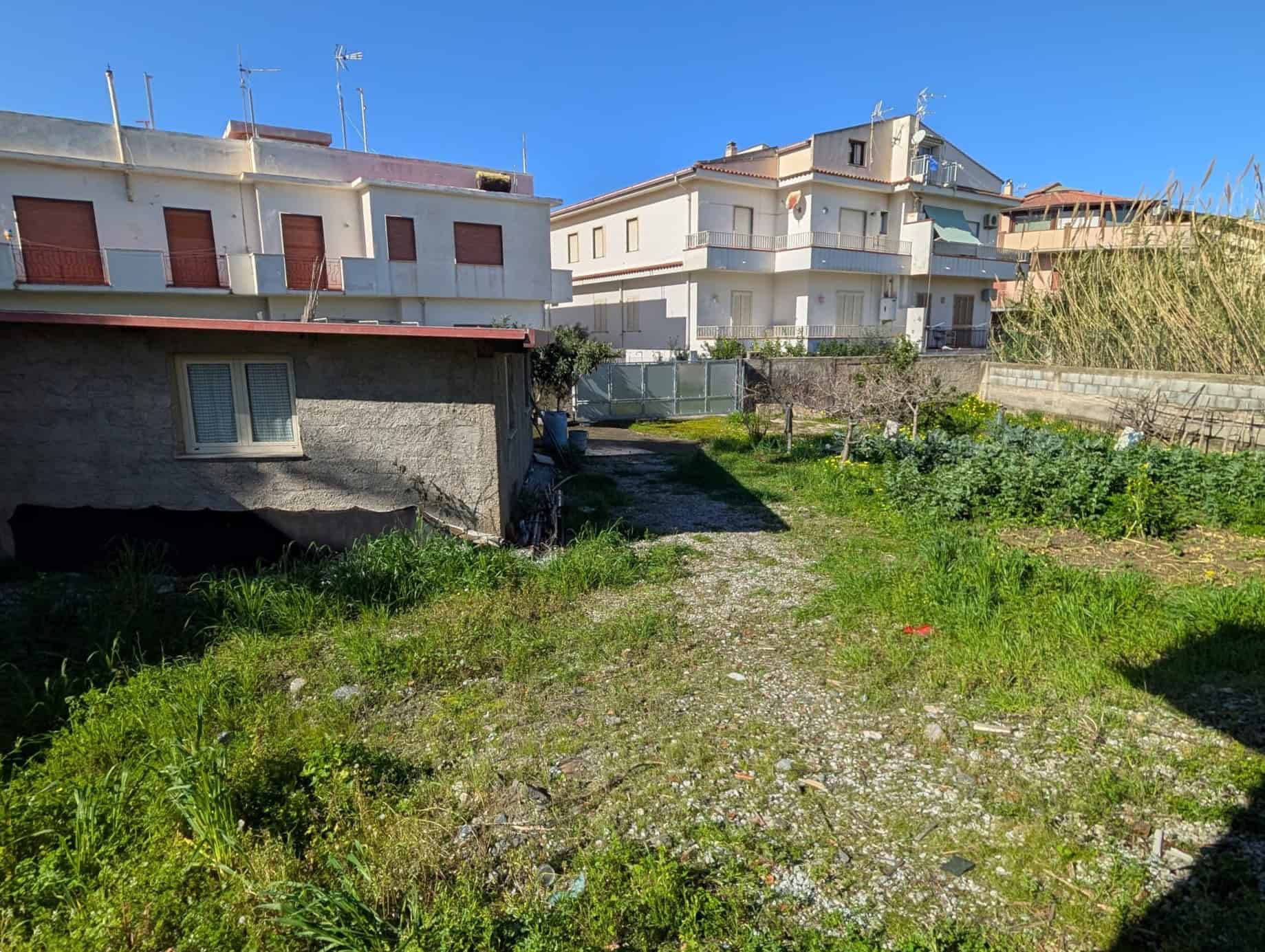 Terreno edificabile in zona residenziale con case moderne e giardini ben curati, ideale per progetti di costruzione o investimento immobiliare a NextCasa.