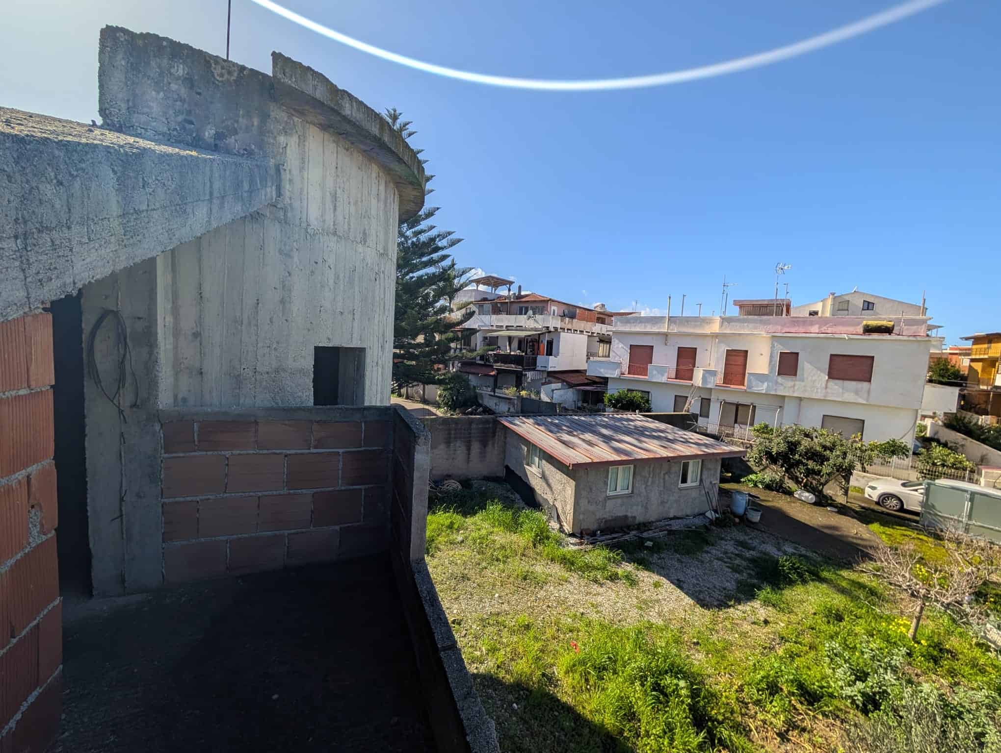 Vista panoramica di un cortile condominiale con edifici residenziali, cielo sereno e spazi verdi, ideale per immobili in vendita o affitto a NextCasa, agenzia immobiliare a Napoli.