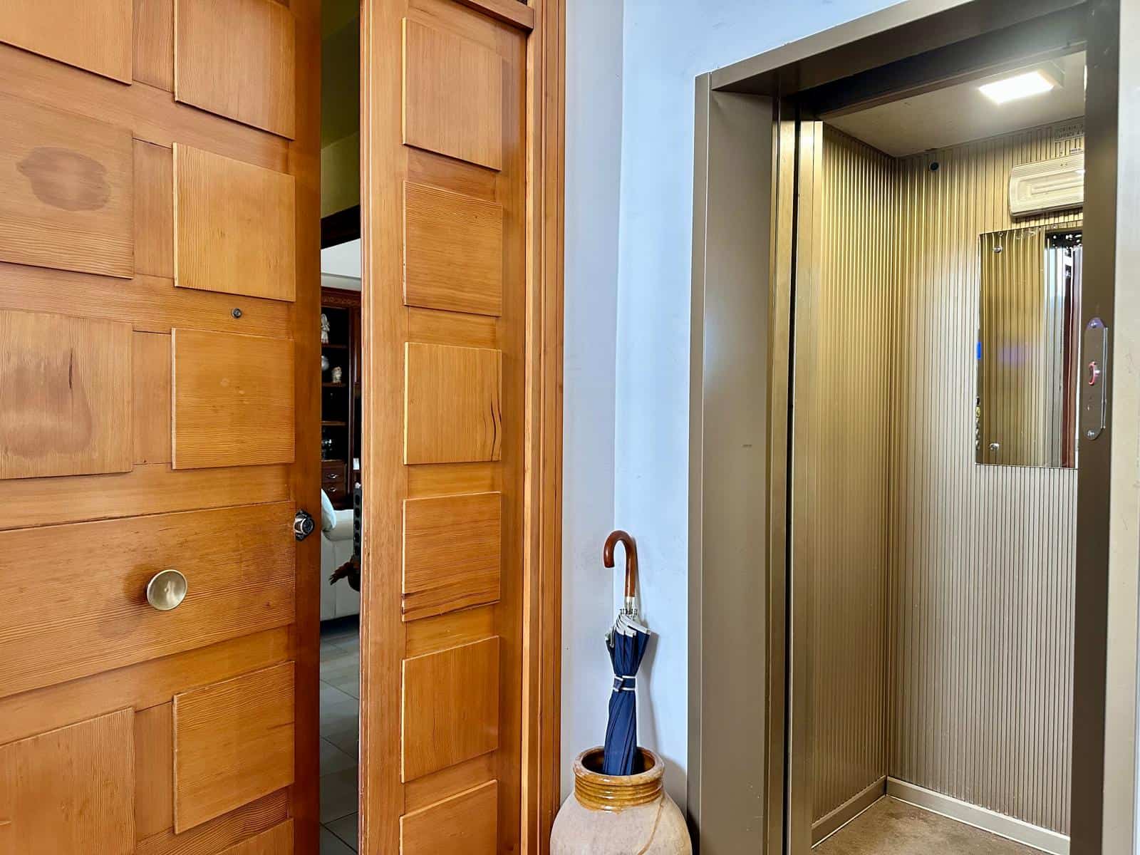 Ascensore moderno in un ambiente domestico con pareti in metallo e illuminazione integrata, ideale per facilitare l'accesso a diverse piani della casa.