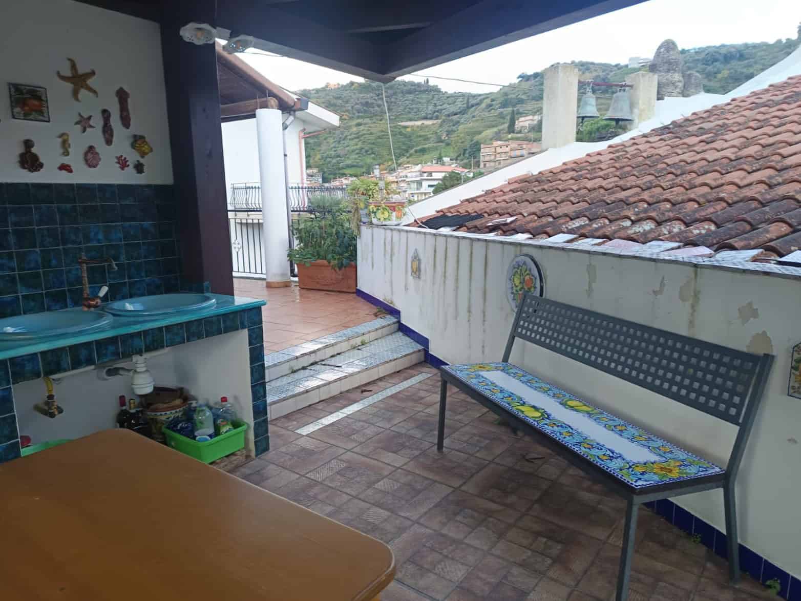 Ampia terrazza con vista panoramica sulle colline, arredi esterni eleganti e spazio per relax e convivialità, ideale per vivere all'aperto in un contesto residenziale tranquillo.