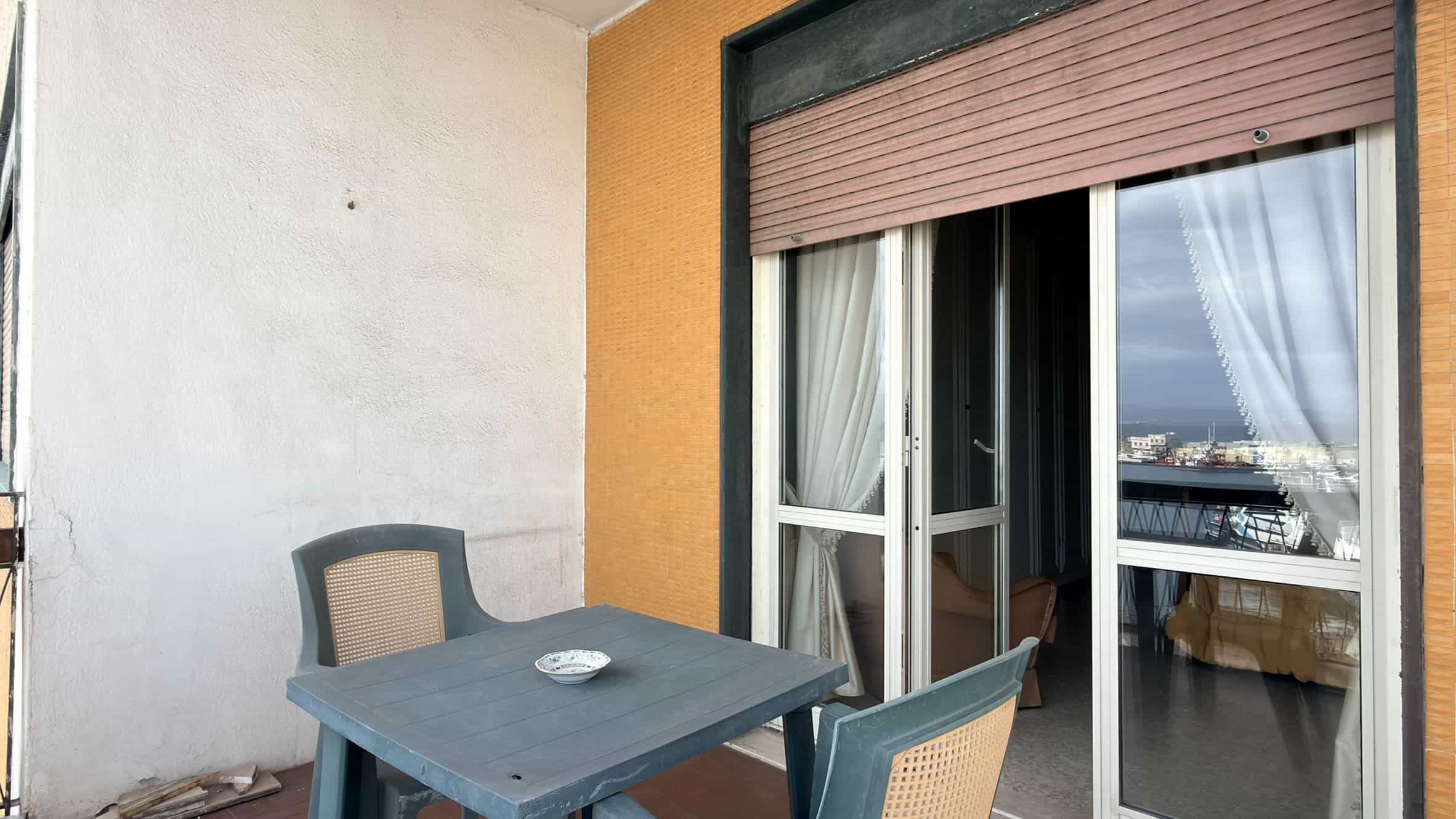 Panca e tavolo da balcone con vista panoramica sulla città, ambiente esterno di un appartamento in stile moderno, ideale per relax e momenti di convivialità all'aperto.