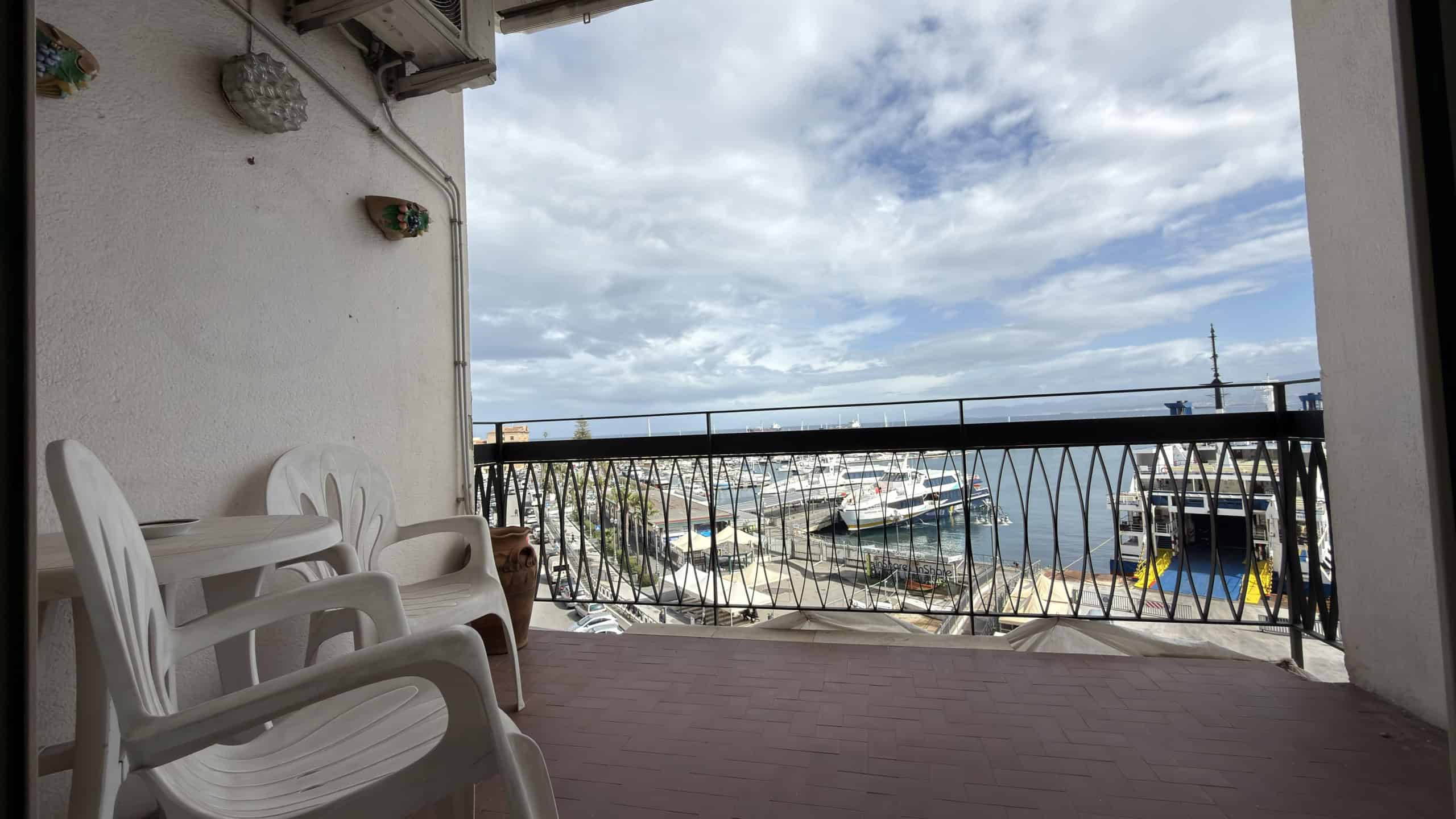 Vista panoramica del porto con barche e yacht dal balcone di un appartamento in affitto a NextCasa, ideale per vacanze rilassanti e soggiorni in mare.