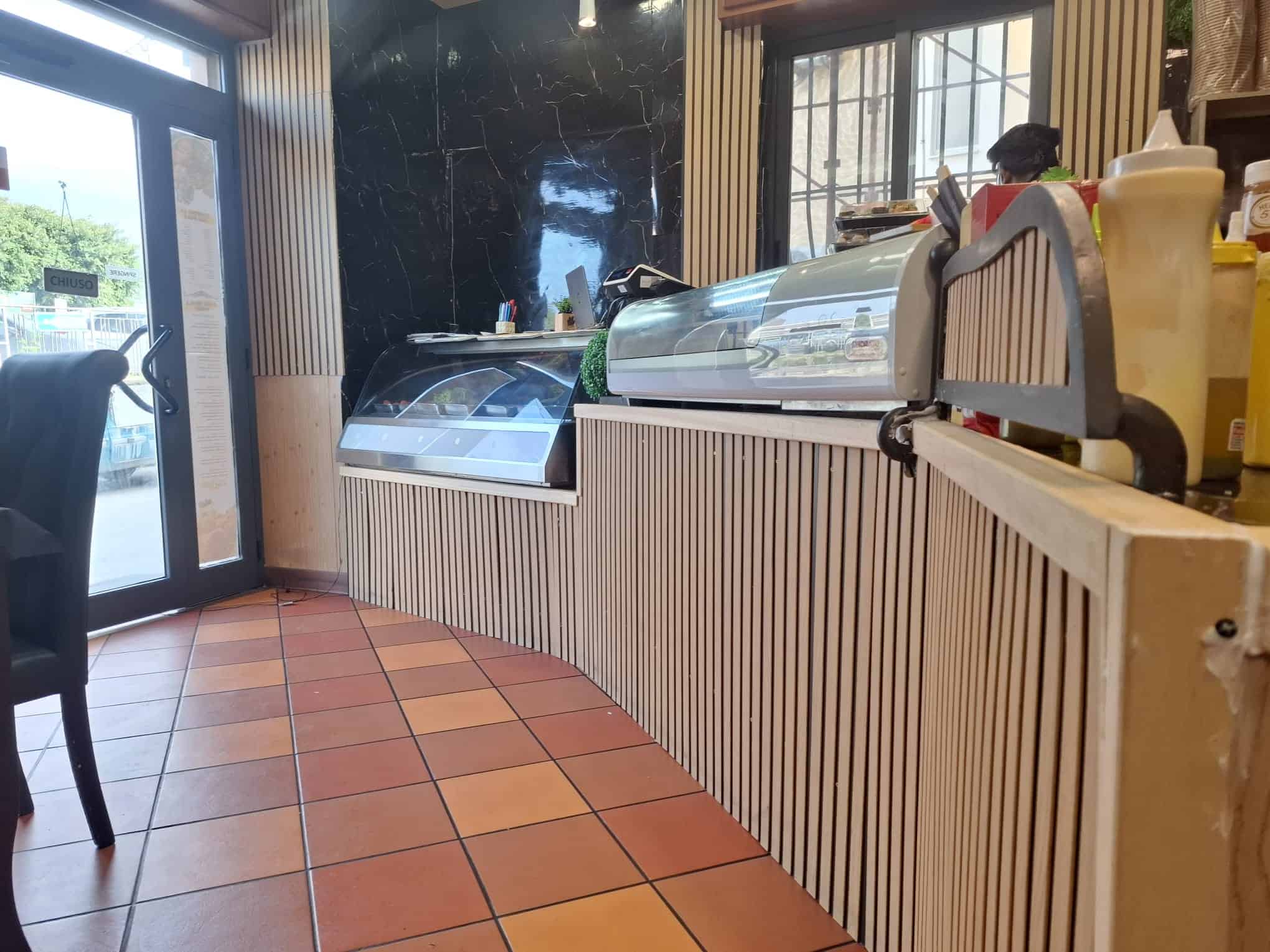 Gelato artigianale in esposizione in una gelateria moderna, con vetrine refrigerate e ambiente accogliente, ideale per gustare dolci freschi e di qualità.