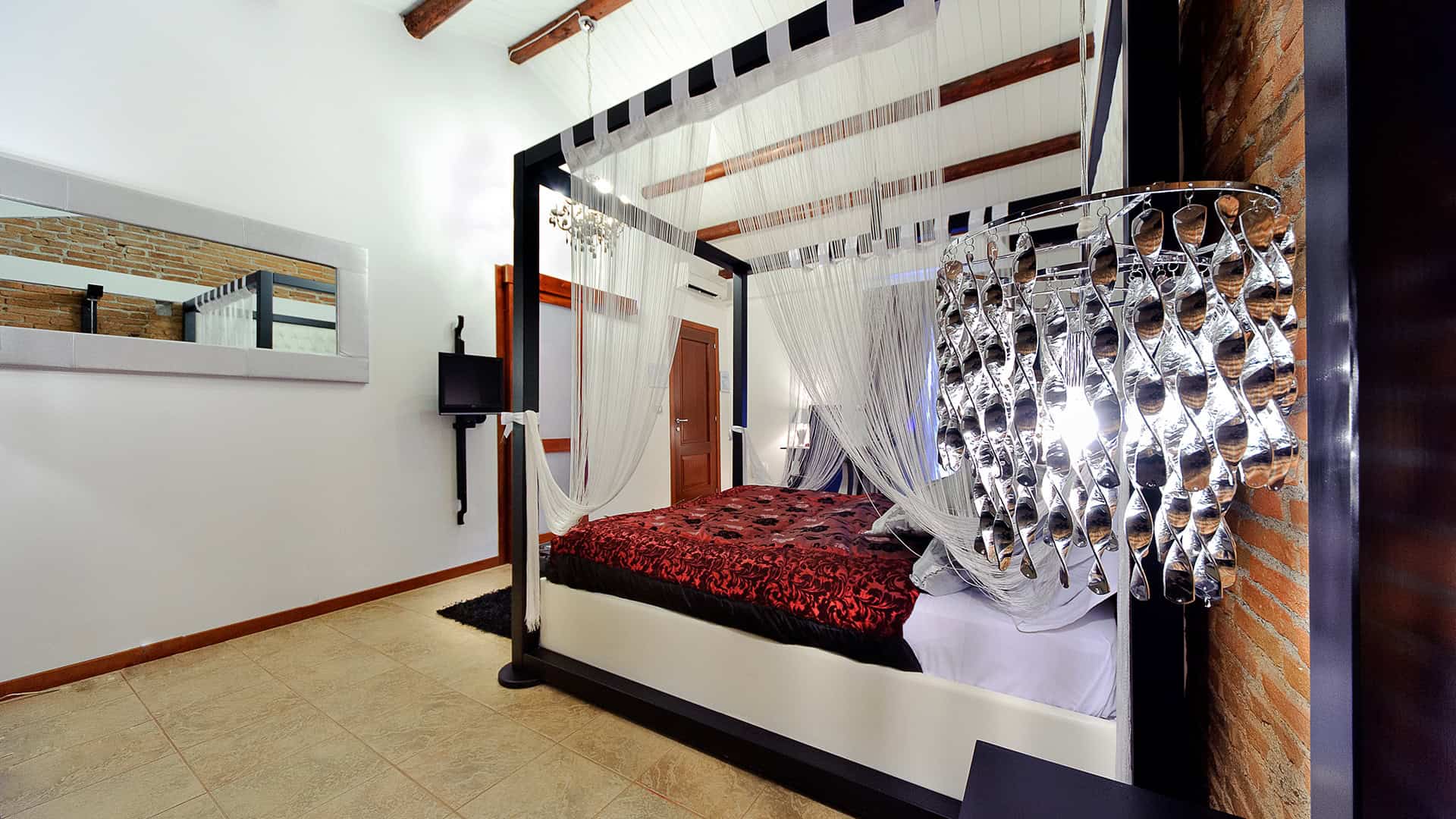 Elegante letto a baldacchino in una camera moderna con pareti bianche e dettagli in legno, ideale per soggiorni di comfort e stile. Perfetto per case di alta qualità e affitti di lusso.