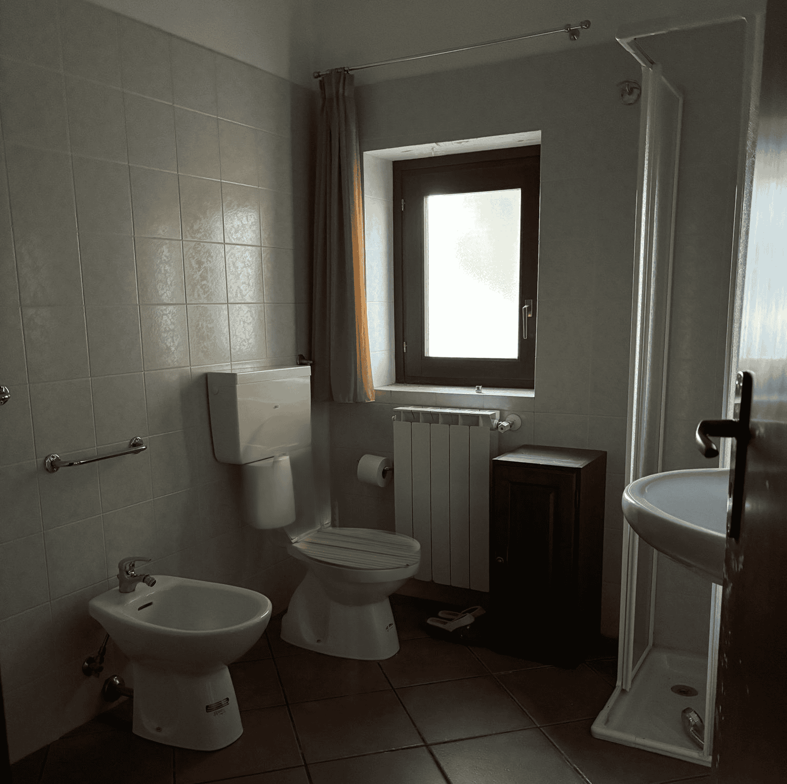 Il bagno con finestra, doccia, WC e bidet in un ambiente luminoso e funzionale, ideale per residenze o affitti turistici, con arredi pratici e spazio ottimizzato.