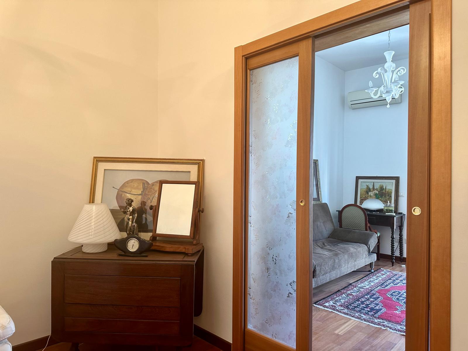 Elegante porta scorrevole in legno con vetro decorativo, ideale per separare ambienti in stile classico e funzionale.