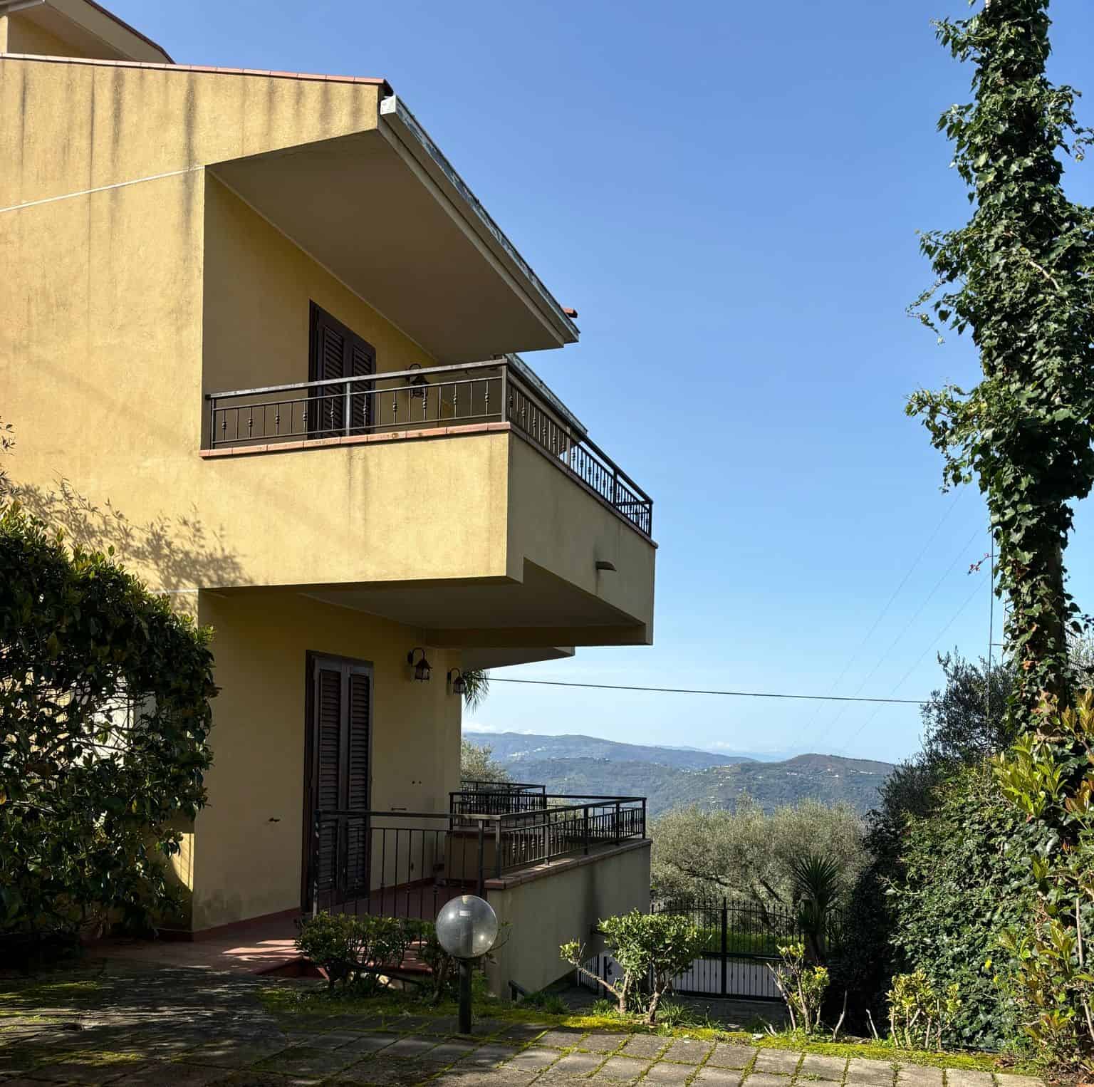 Ampia casa con balconi e vista panoramica sulle colline circostanti, immersa nel verde e ideale per vivere in tranquillità e comfort.