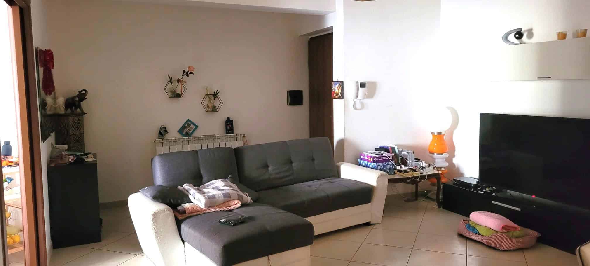 Divano moderno in soggiorno con decorazioni e oggetti di design, ambiente luminoso e accogliente.