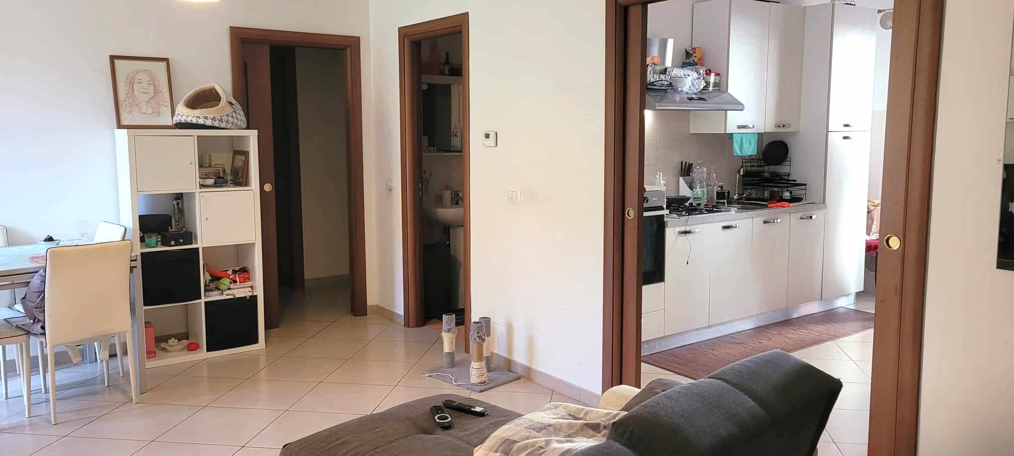 Ampia vista di un soggiorno e cucina open space in stile moderno, con arredi funzionali e luminosi, ideale per vivere e rilassarsi in casa.