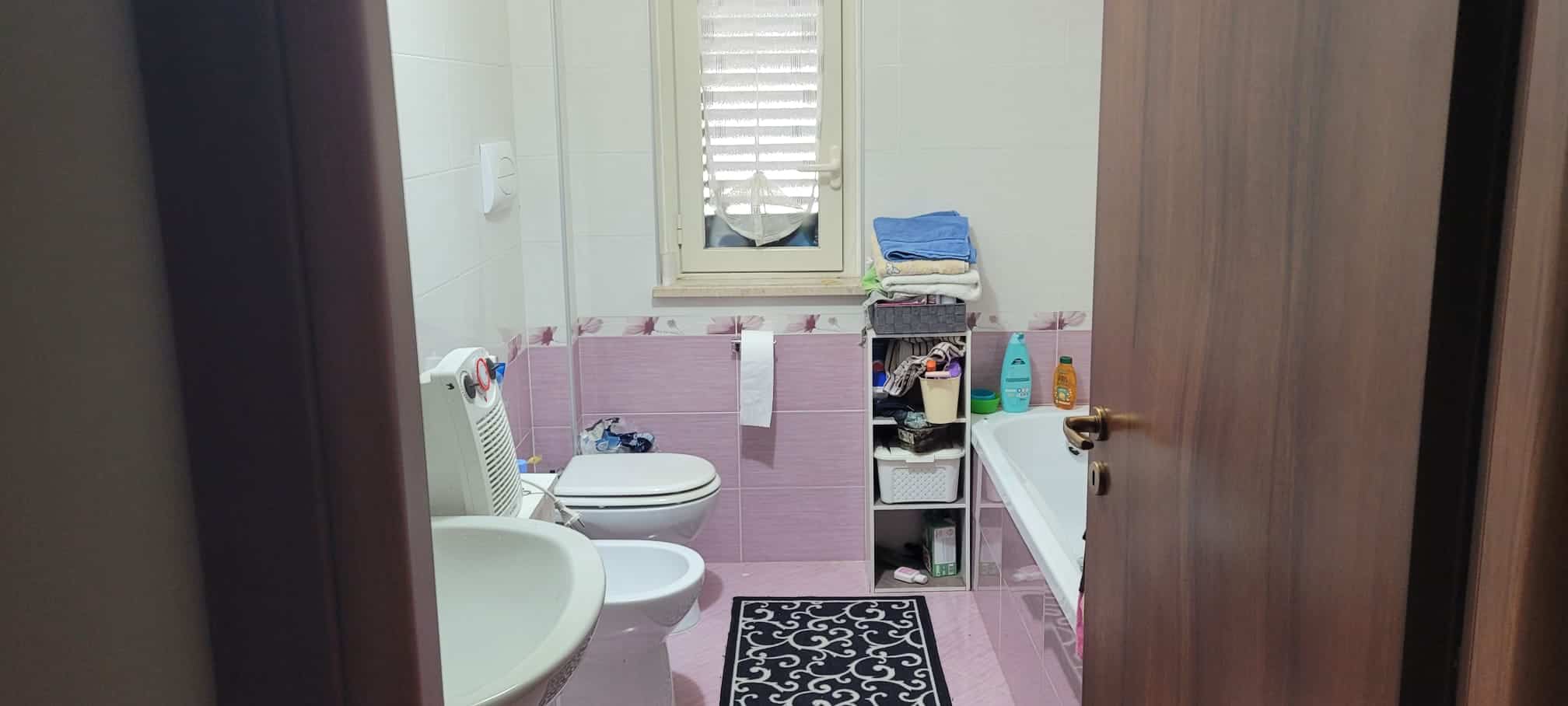 Bagno con sanitari e vasca da bagno, arredamento funzionale e dettagli pratici, ideale per soluzioni di ristrutturazione e design d'interni.