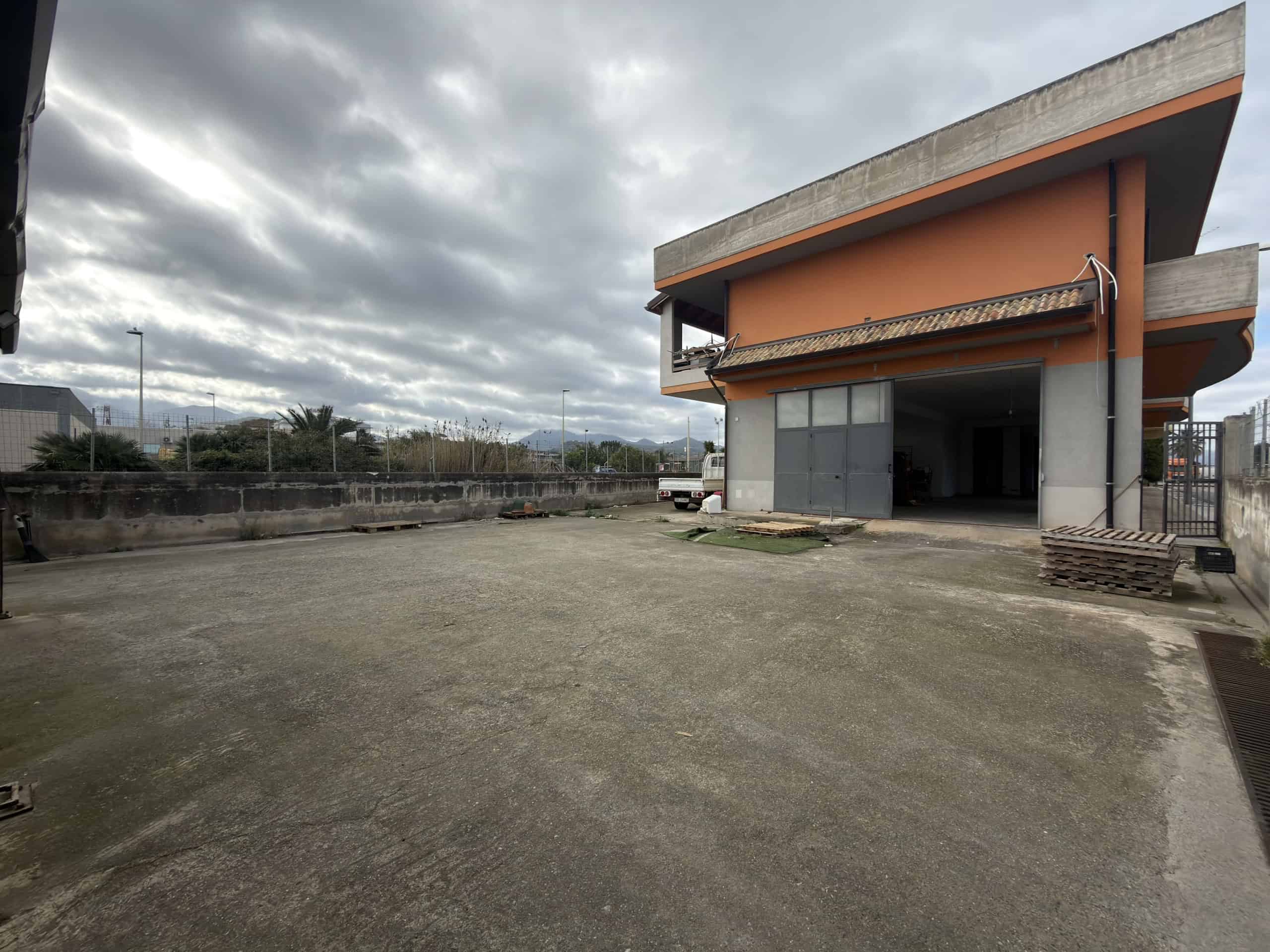 Edificio residenziale in costruzione con ampio spazio esterno e cielo nuvoloso, pronto per essere completato, situato in un'area urbana.