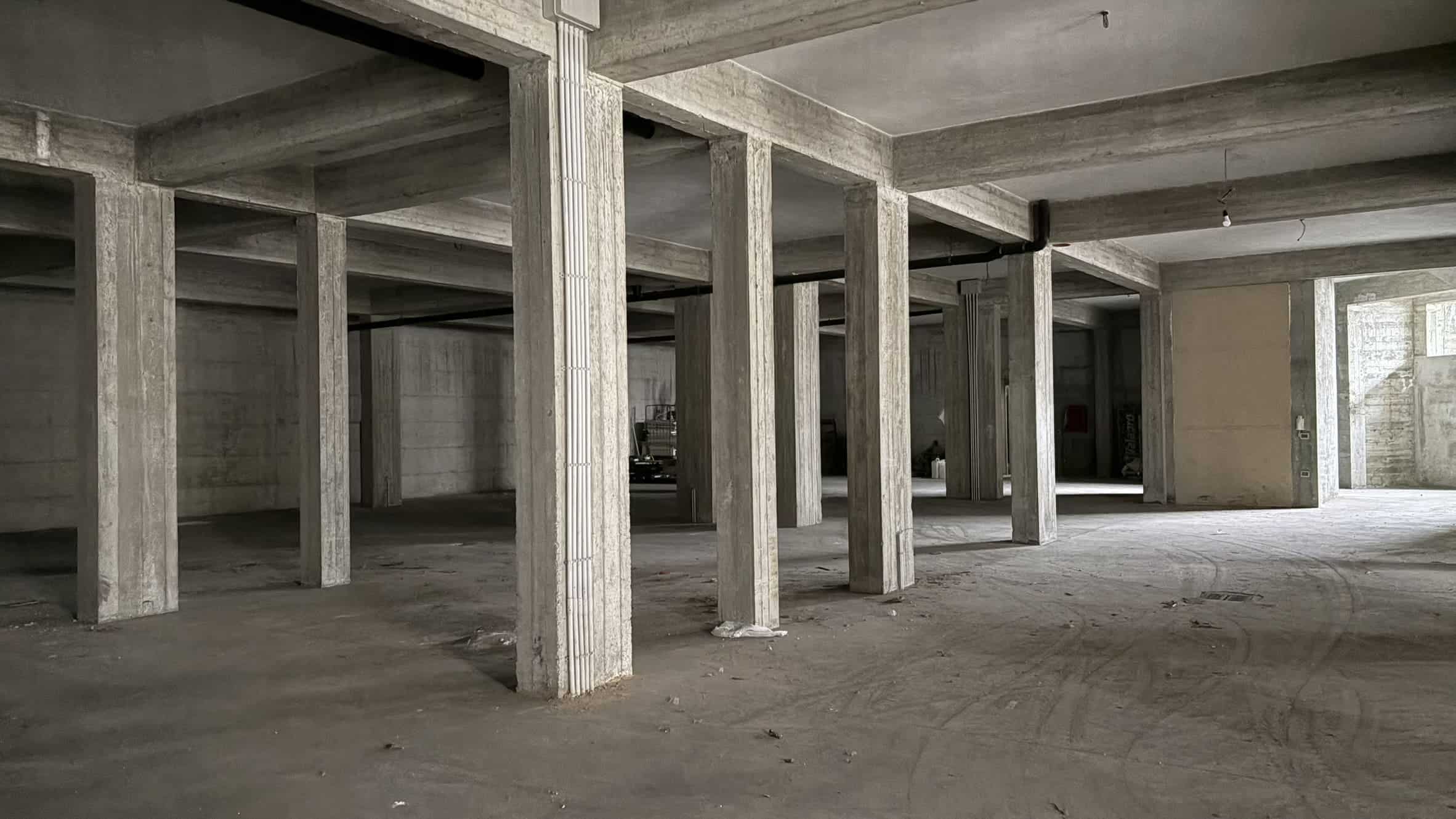 Cantiere edile con strutture in cemento armato, pronto per la costruzione di un edificio residenziale o commerciale. Spazio aperto e luminoso, ideale per progetti di sviluppo immobiliare.