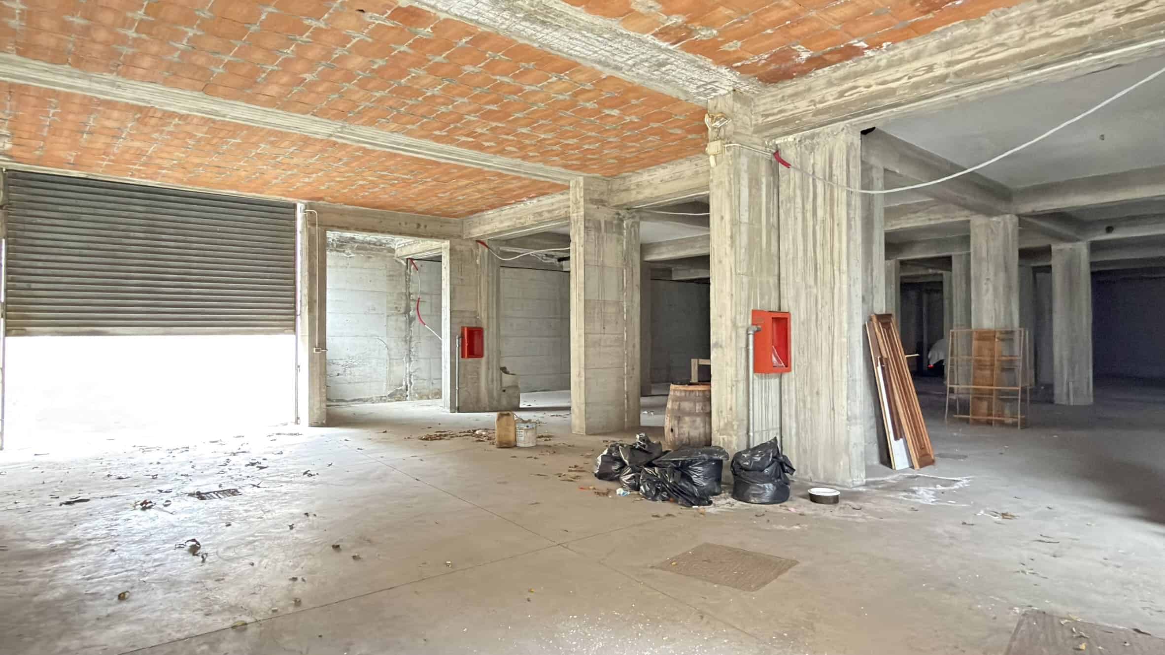 Pannello di apertura garage in costruzione con struttura in cemento e pareti in mattoni, pronto per essere rifinito e personalizzato.