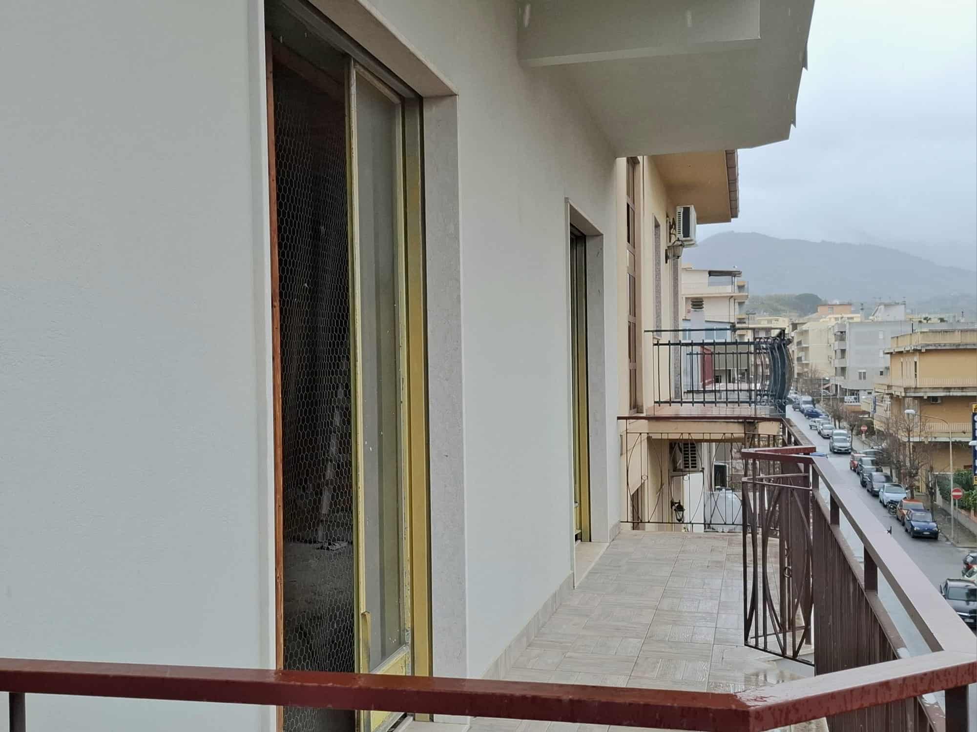 Appartamento con balcone panoramico in zona urbana, vista sulla strada e sui edifici circostanti, ideale per soggiorni in città e relax all'aperto.