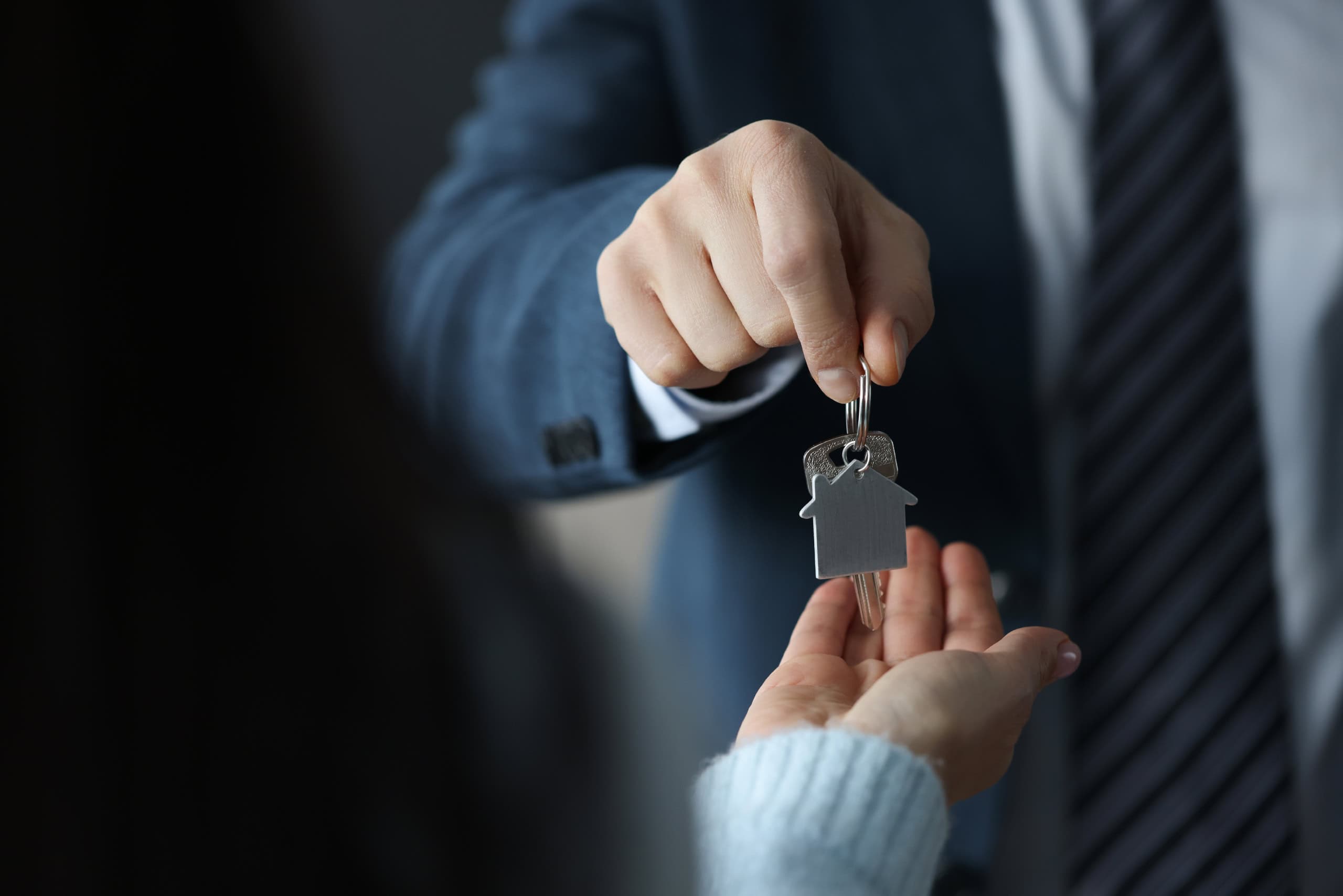 Vendita di casa con chiavi in mano, agente immobiliare consegna le chiavi a un cliente, immagine di un accordo immobiliare, servizio di intermediazione immobiliare, concetto di compravendita immobilia.