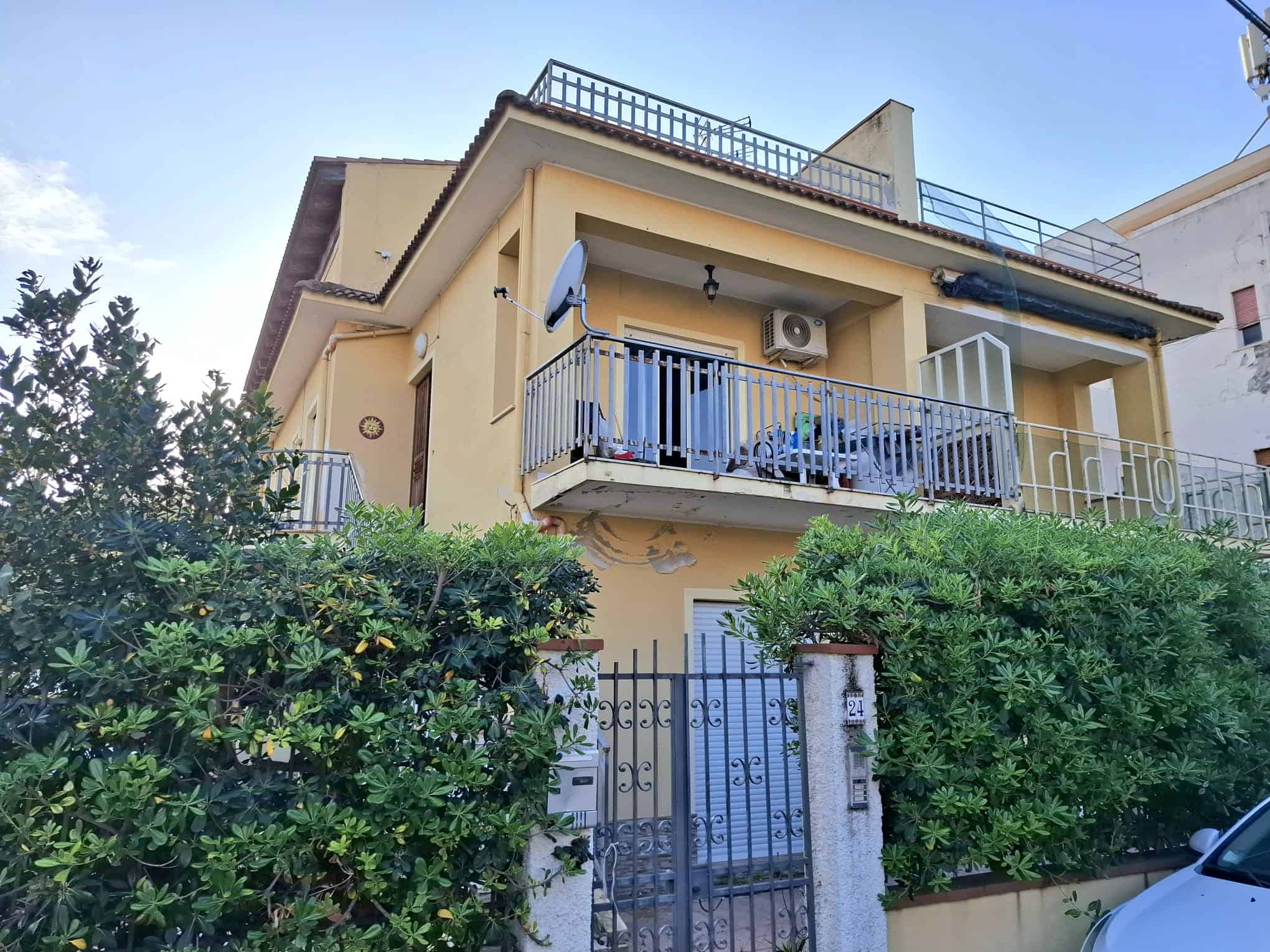 Casa con balcone e giardino in zona residenziale, ideale per famiglie, con spazi esterni ben curati e ambiente tranquillo.