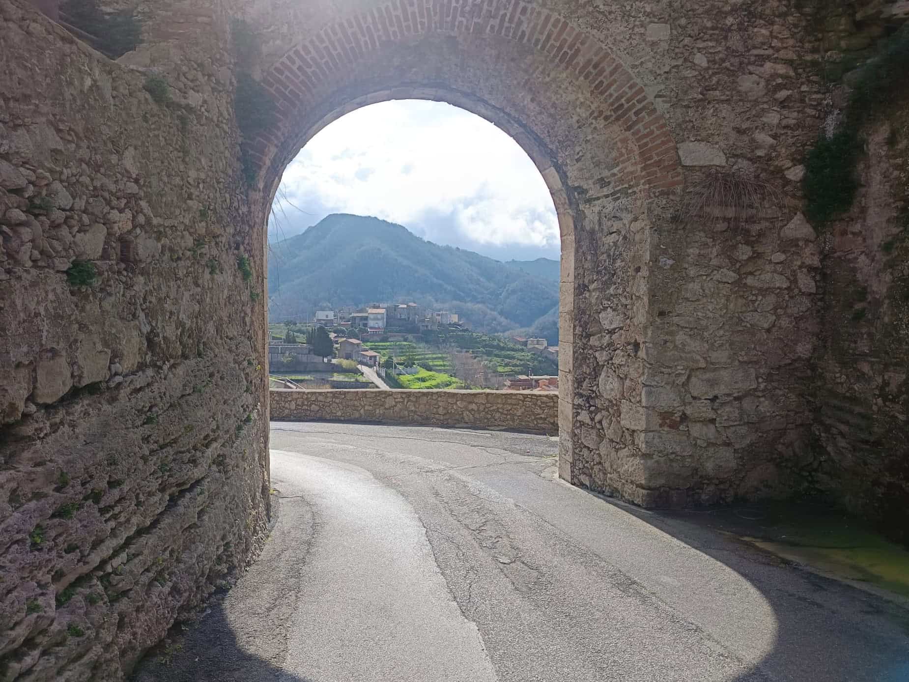Varchi storico in pietra con vista panoramica sulle montagne e paesaggi rurali, ideale per immagini di patrimonio culturale e architettura antica.