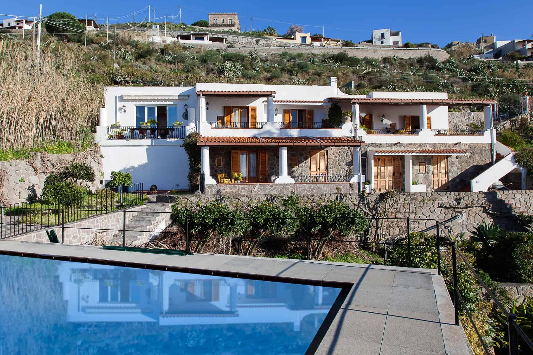 Villa moderna con piscina e vista panoramica sulla collina.