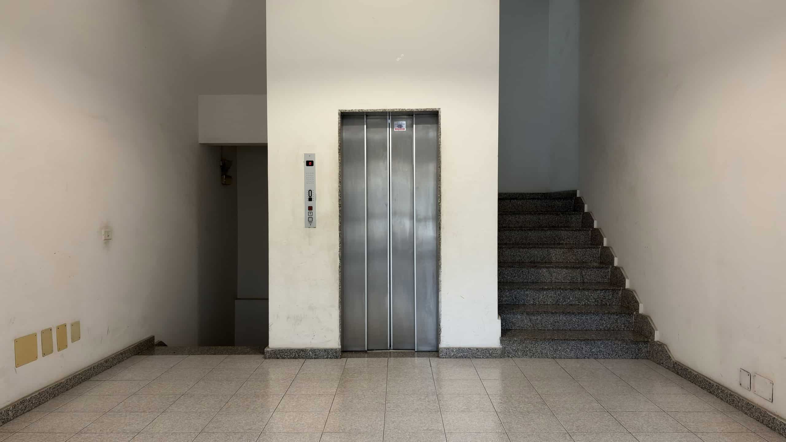 Ascensore condominiale in un edificio moderno, situato tra le scale, pronto per il trasporto di persone e bagagli.